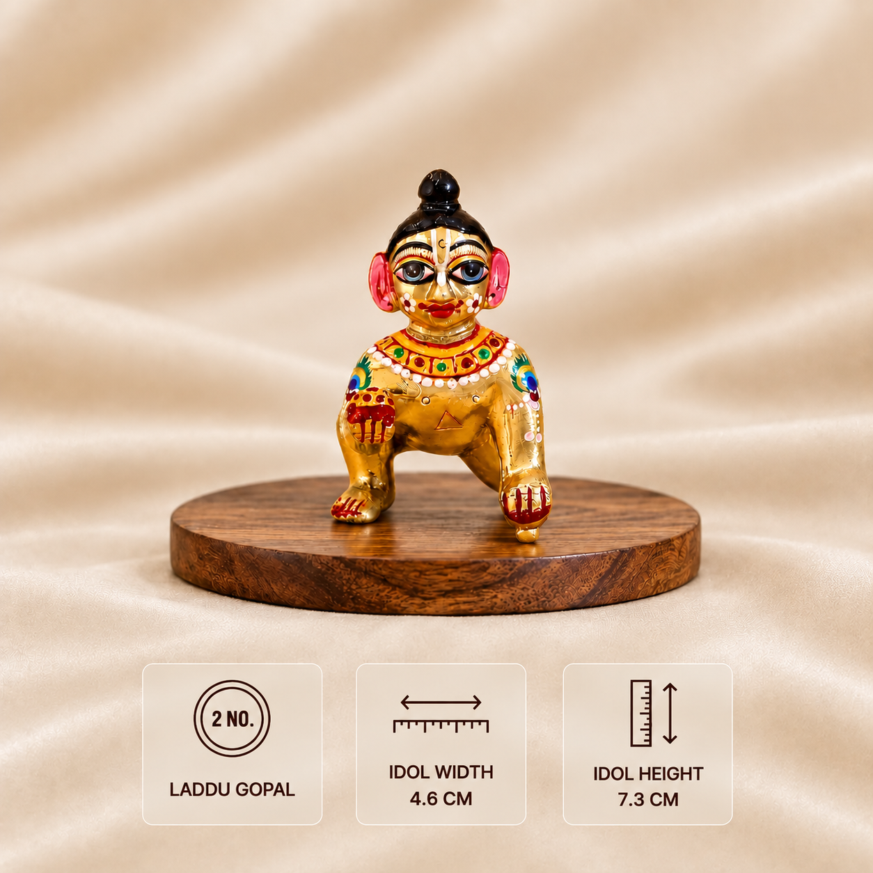 Front view of a golden Laddu Gopal idol holding a sweet on a wooden platform, 4.6 cm wide and 7.3 cm high