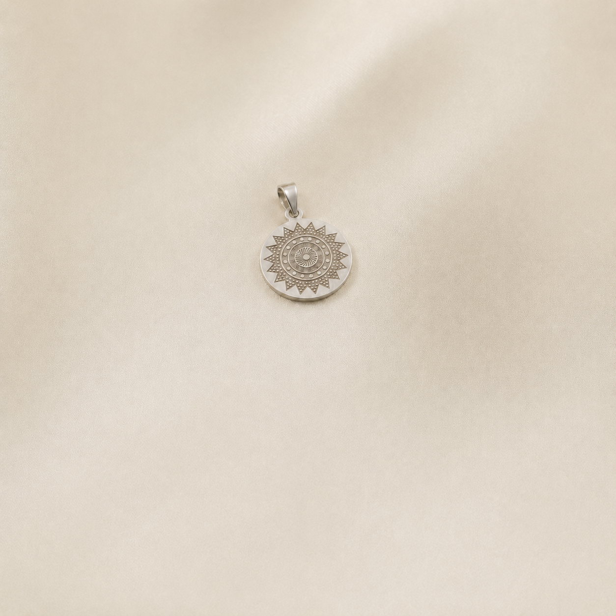 925 silver round disc design pendant measuring 36 x 22 mm on a smooth ivory satin background