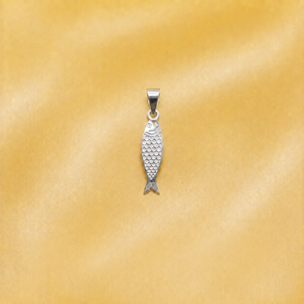 925 silver fish pendant displayed on a smooth golden satin background