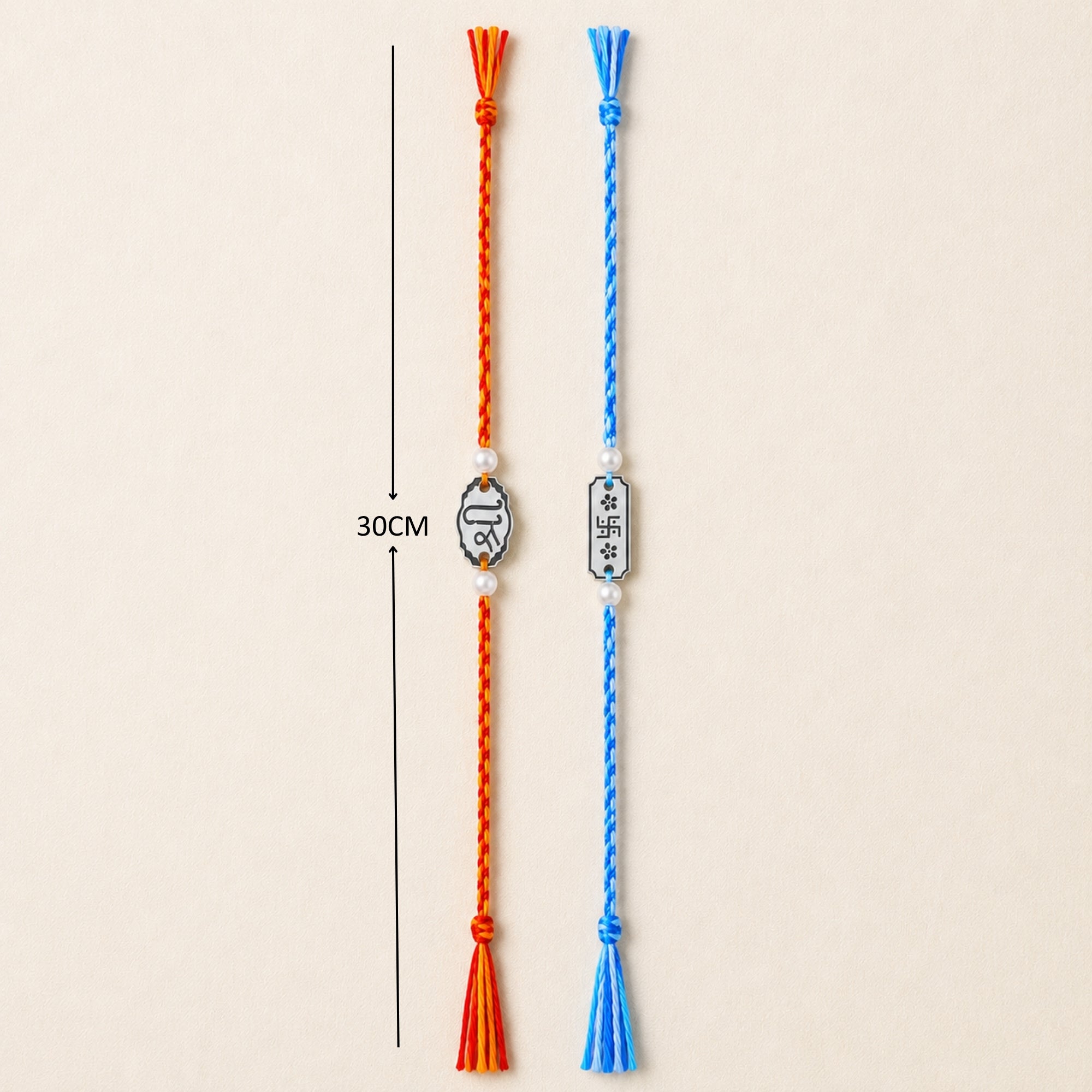 Two 925 sterling silver Shree and Swastika oval charm rakhis with pearl beads laid out vertically