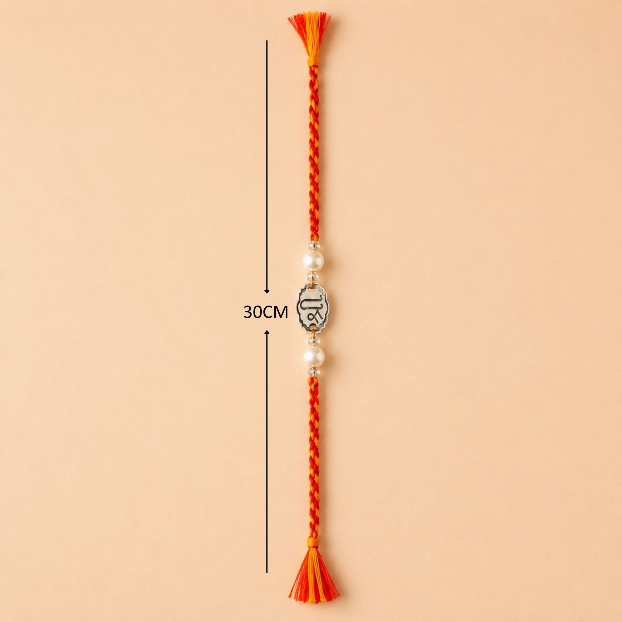 Full length layout showing thread length and tassels of 925 silver Shree symbol rakhi