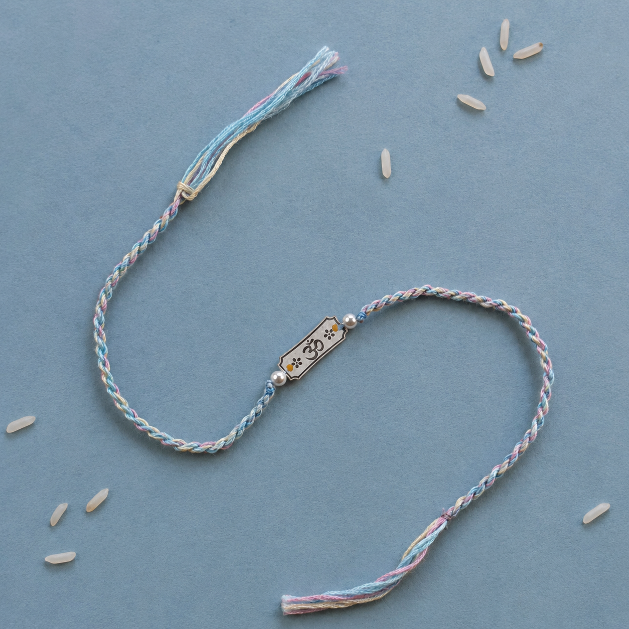925 pure silver Subh Om Labh inscribed charm rakhi with pearl beads on pastel sky blue cord