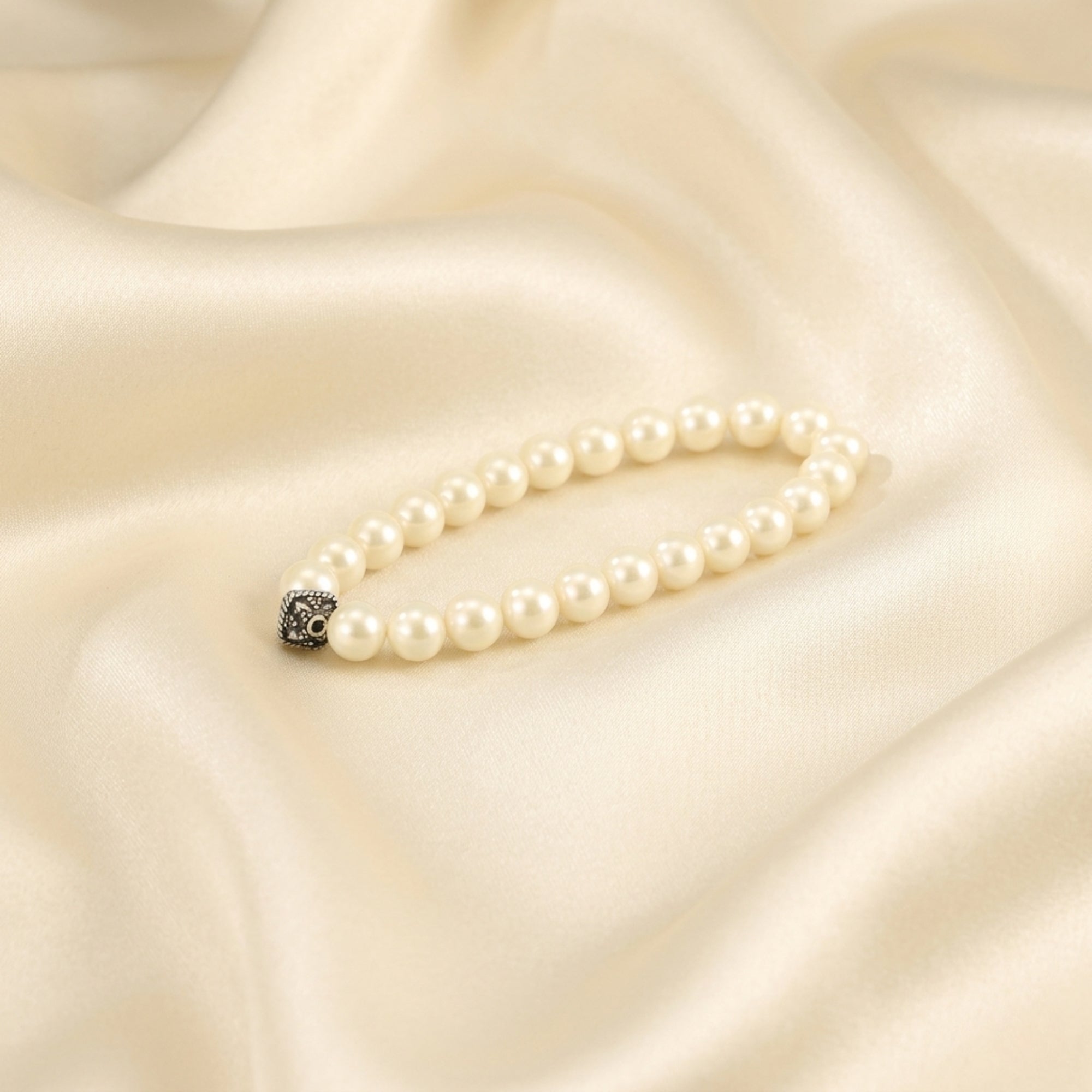 925 sterling silver natural white moti pearl bracelet displayed on cream silk fabric