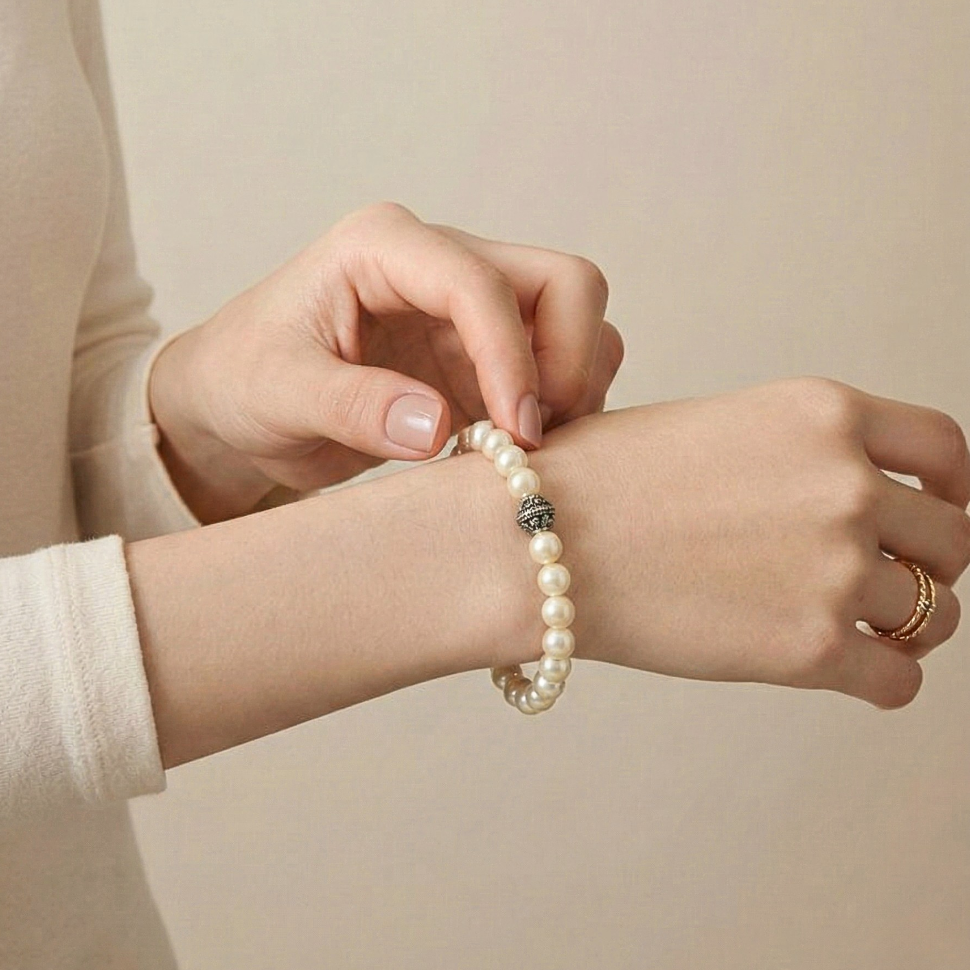 Model adjusting 925 sterling silver natural white moti pearl bracelet on wrist