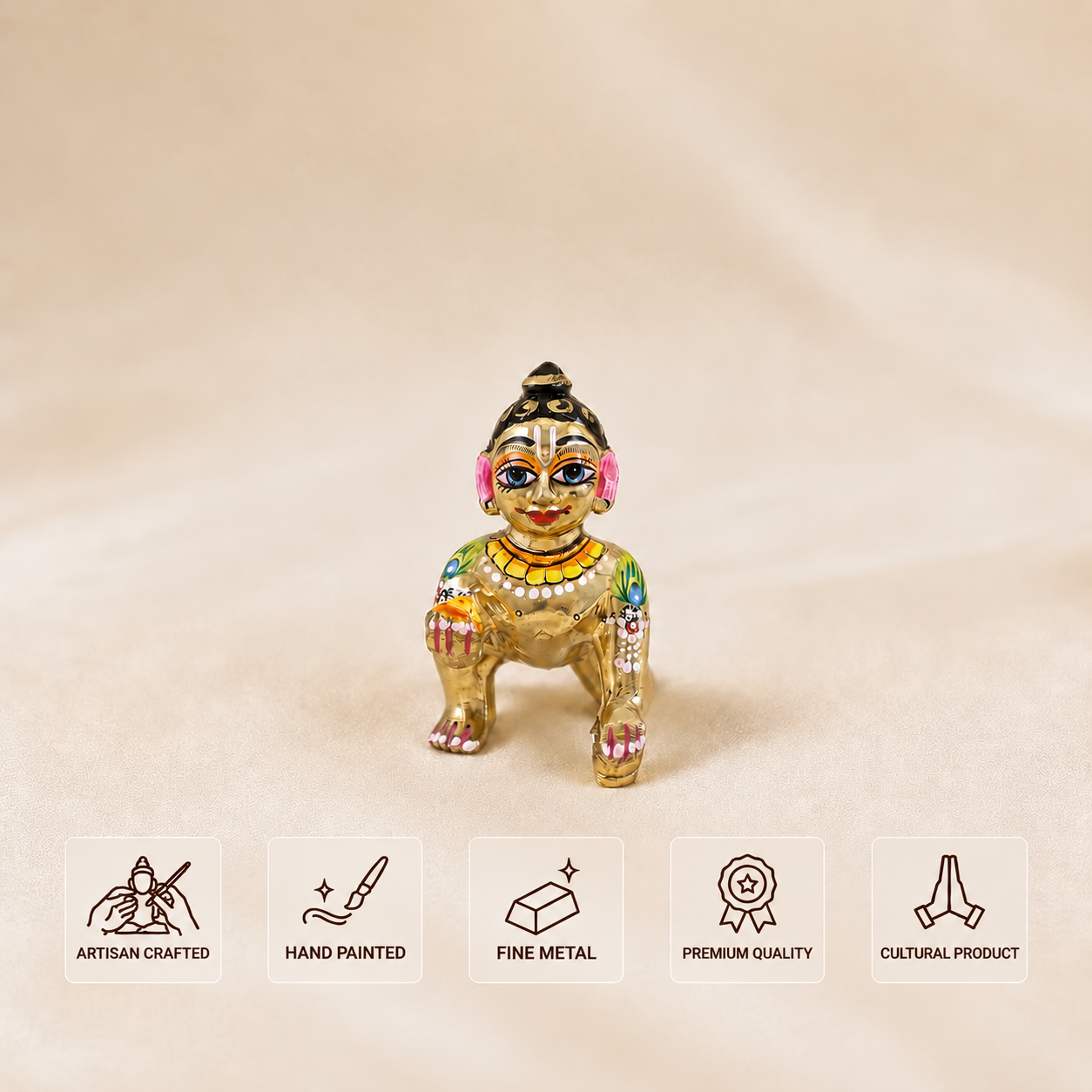 A small hand-painted metallic figurine of a traditional deity, shown on a beige fabric background with five feature icons at the bottom indicating artisan craftsmanship, hand painting, fine metal, premium quality, and cultural product.