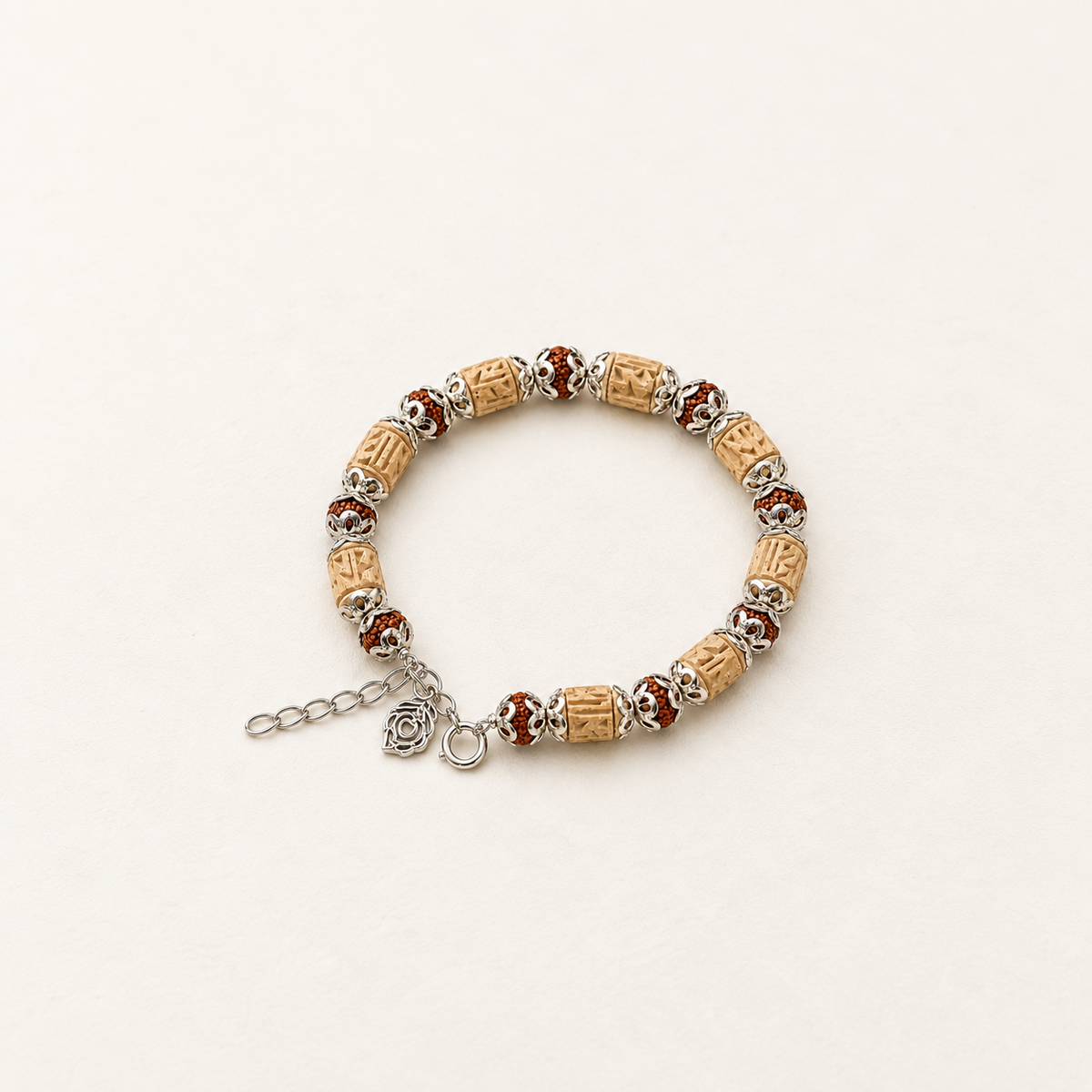 Handcrafted carved bead bracelet with tan and brown beads, silver filigree spacers, extender chain
