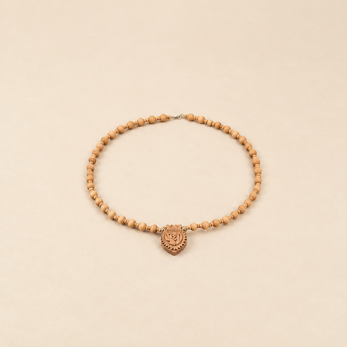Handcrafted wooden Tulsi mala with natural light-brown beads, carved heart-shaped pendant and silver clasp 