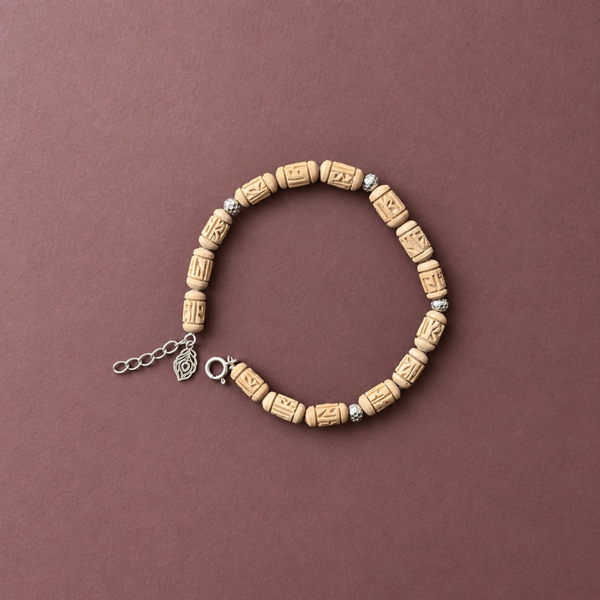 Handcrafted carved wooden bead bracelet with silver spacers, adjustable chain and feather charm