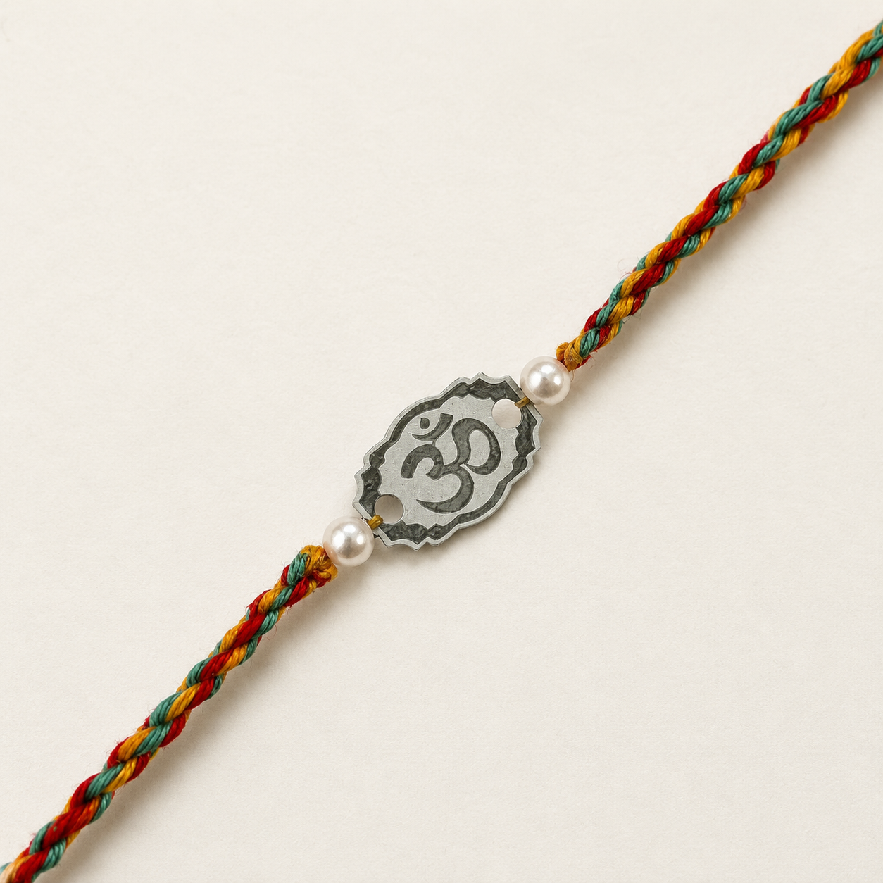 Close-up of Pure Silver Om Rakhi for brother showing antique silver charm and pearl details