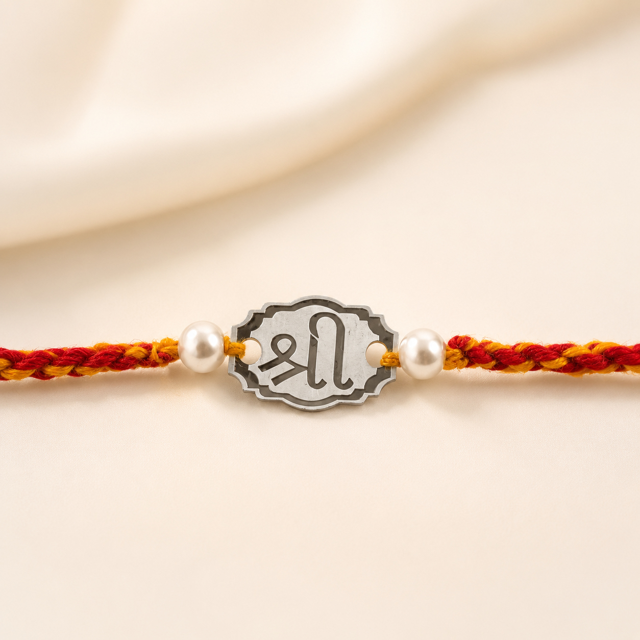 Close-up of Pure Silver Shree Rakhi for brother showing metallic charm and pearl details