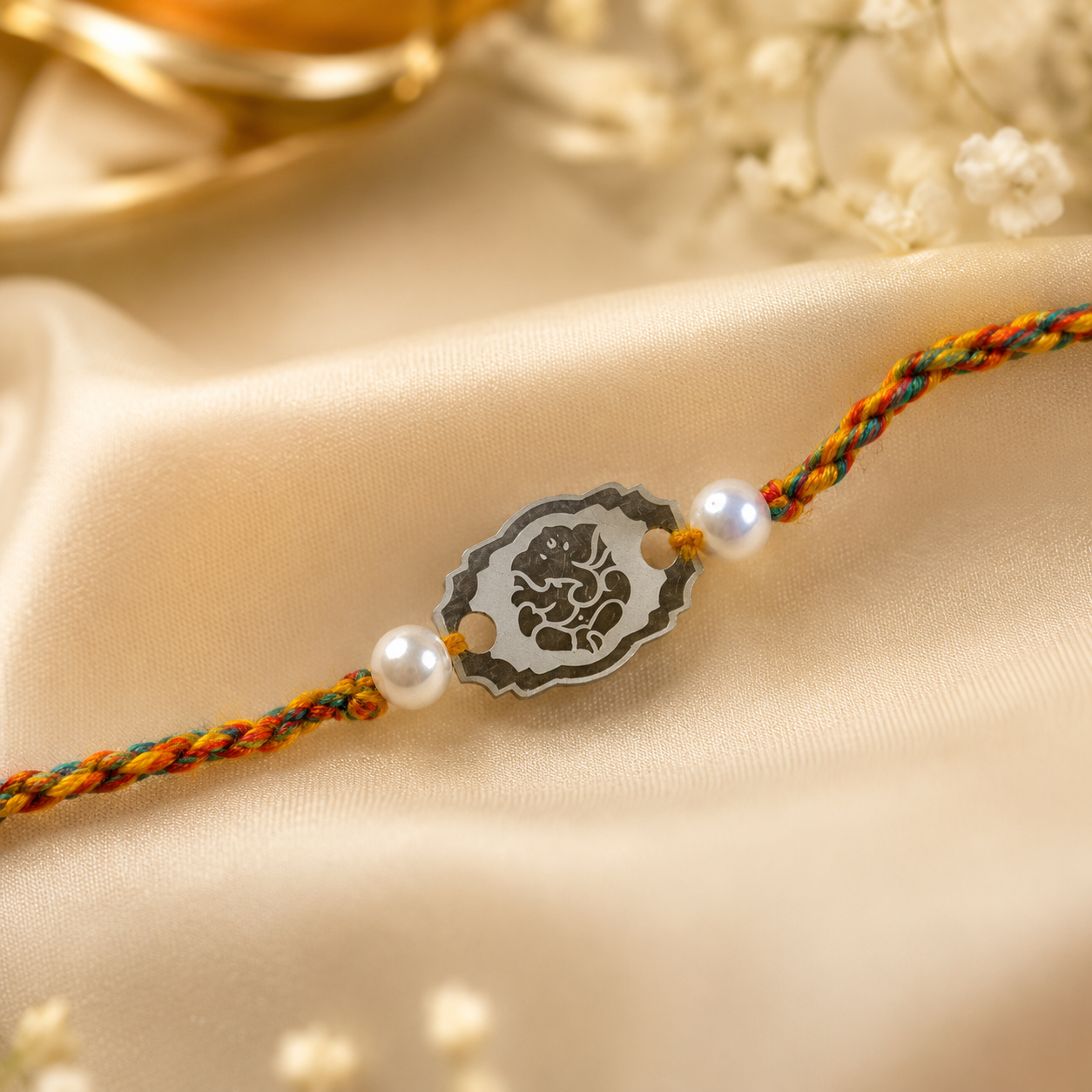 Close-up view of Pure Silver Ganesha Rakhi showing Lord Ganesha charm and pearl details