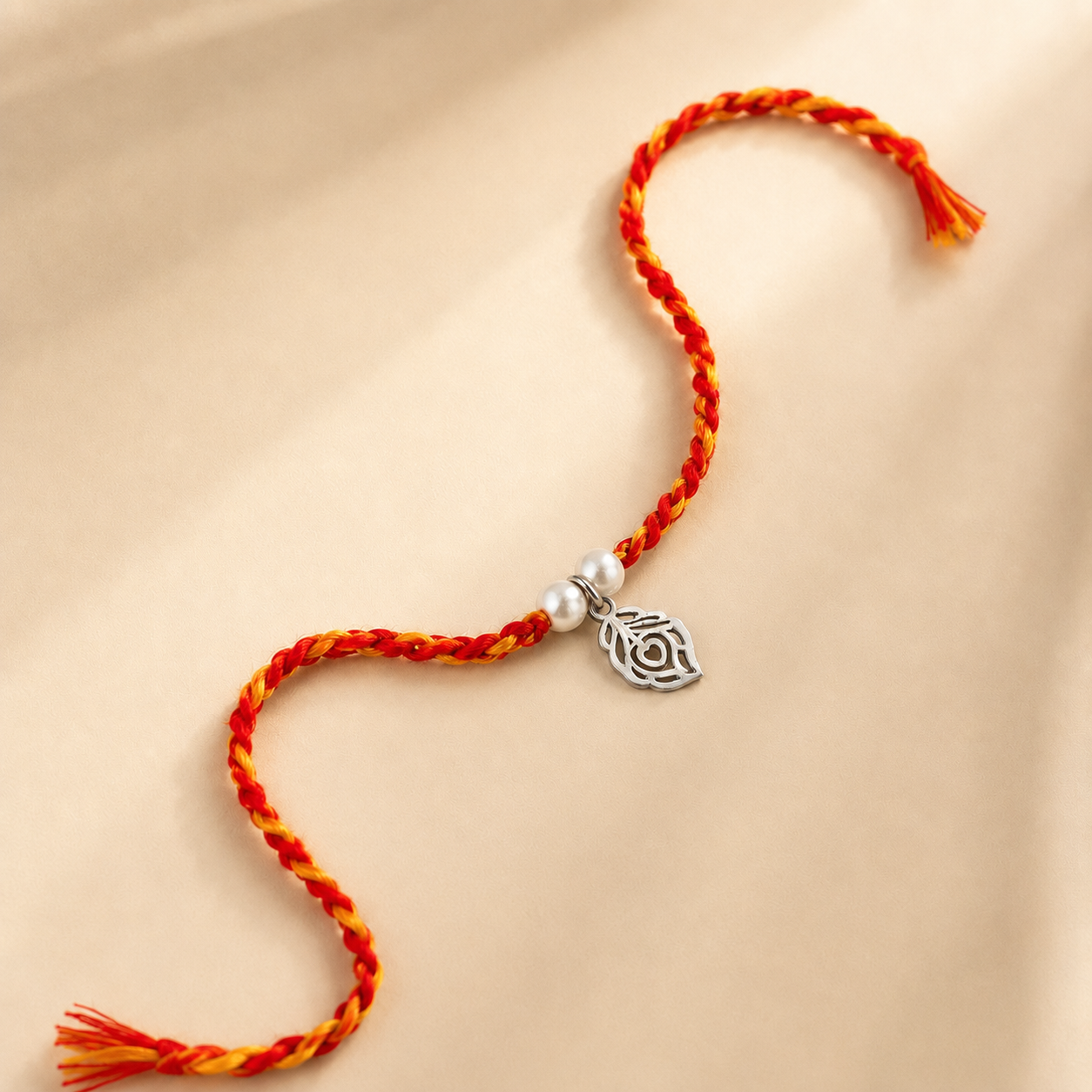 Silver Morpankh Rakhi for brother with pearl beads and red orange braided thread
