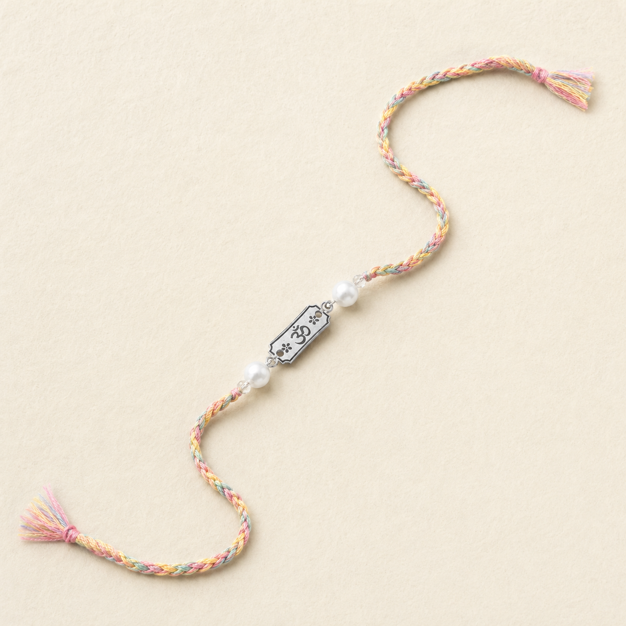 Silver Rakhi for brother with pearls engraved Om center and pastel braided thread