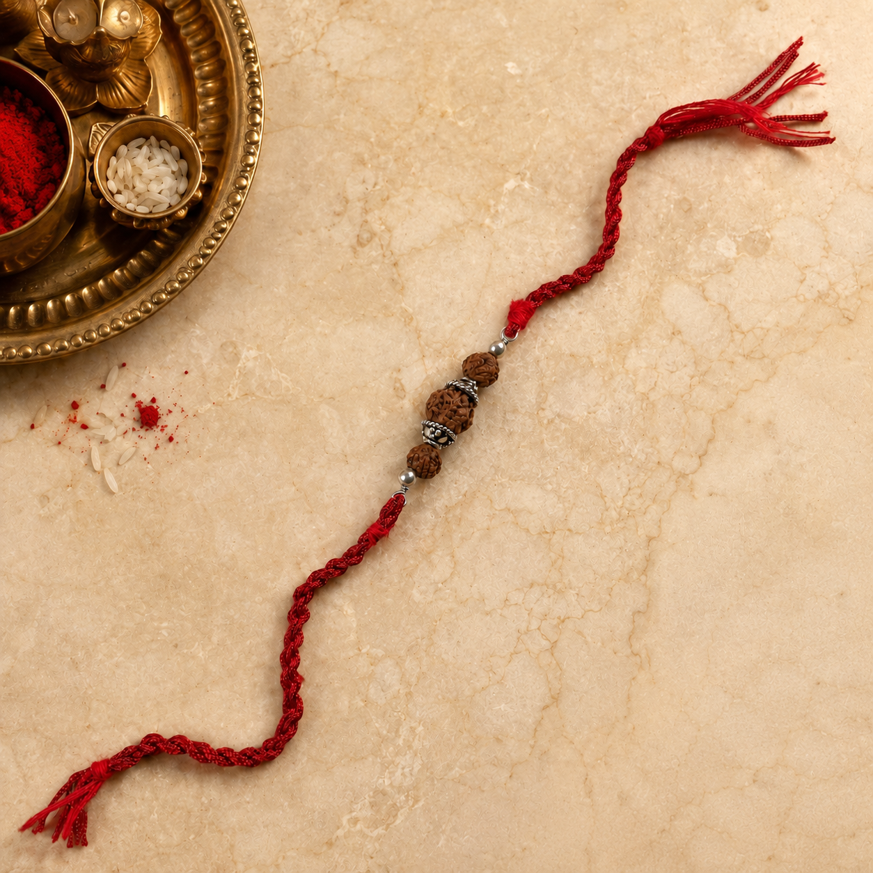 Rudraksha silver capping Rakhi for brother with red braided thread front view