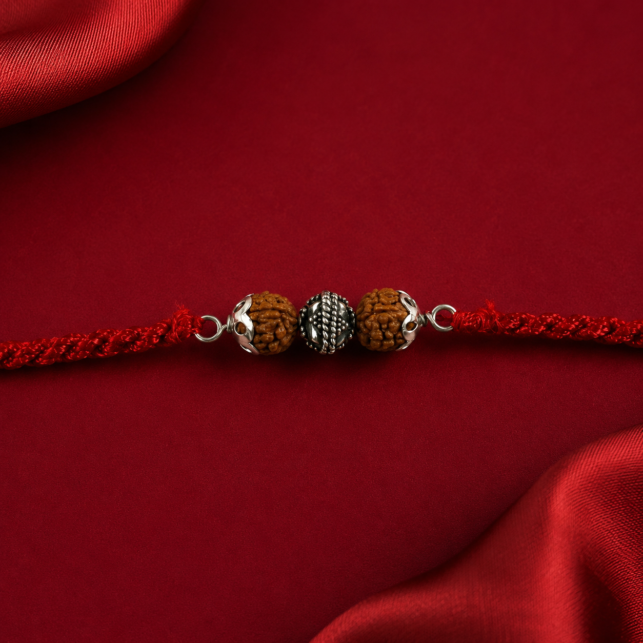 Close-up view of silver Chandi centerpiece and natural Rudraksha beads on Rakhi thread