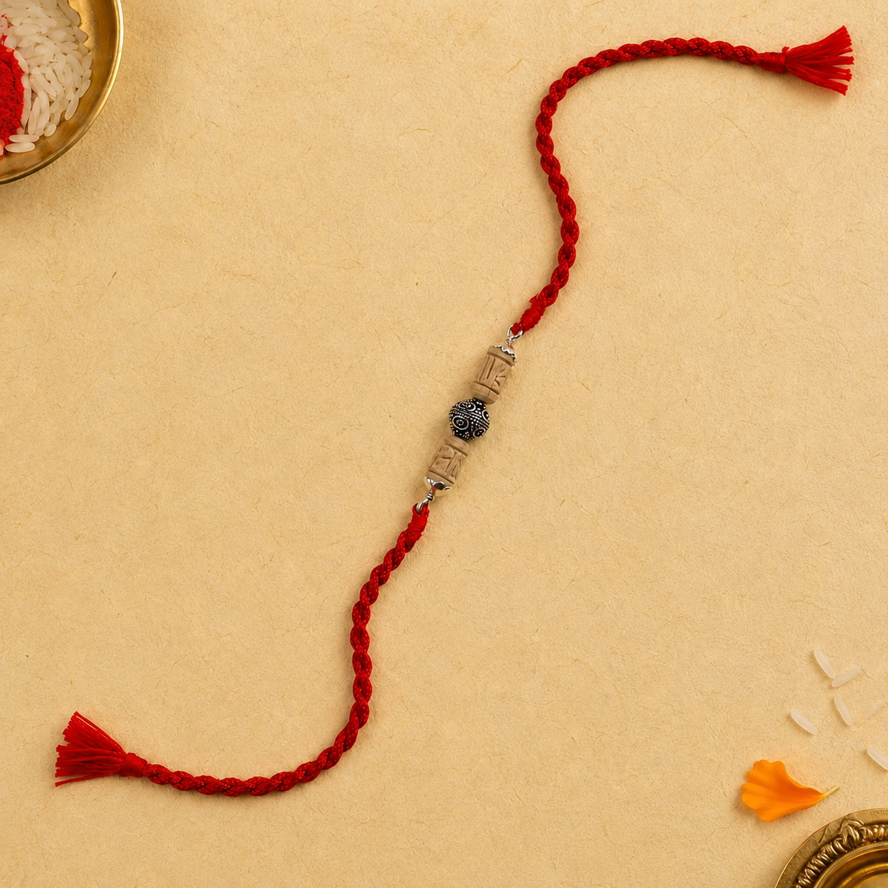Designer silver Tulsi Rakhi for brother with red Mauli thread front view