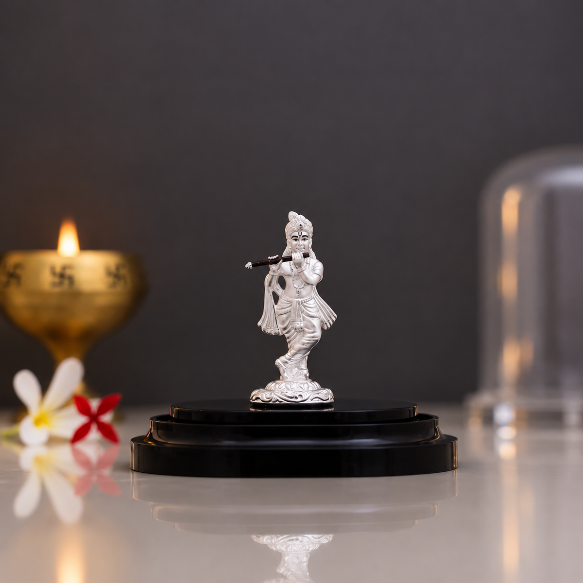 Silver Krishna idol playing a flute 