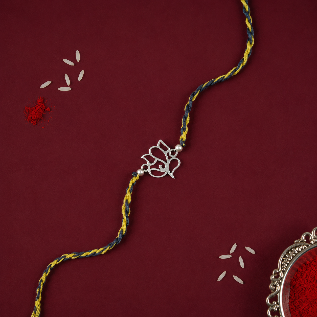 Full Silver Ganesh Rakhi with openwork charm, two round beads and braided thread