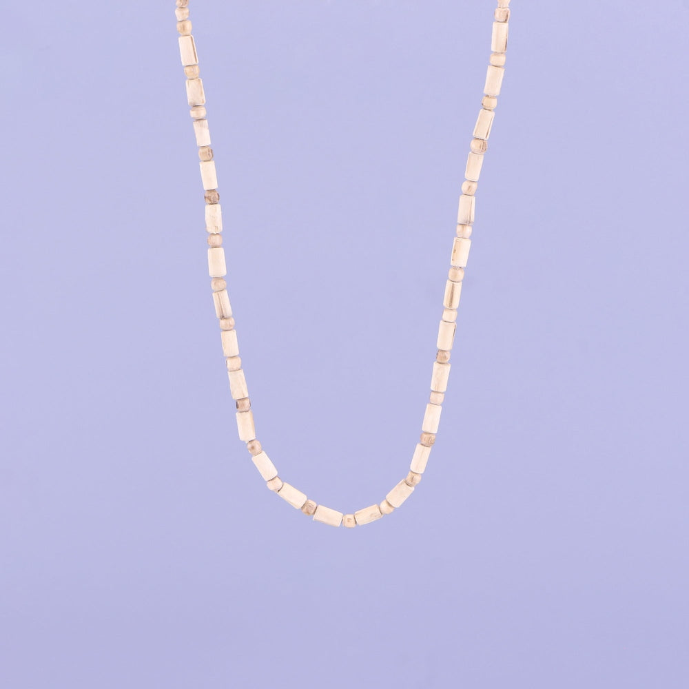 Close up of an alternating pattern of pure wooden round and cylindrical beads on a Tulsi kanthi mala