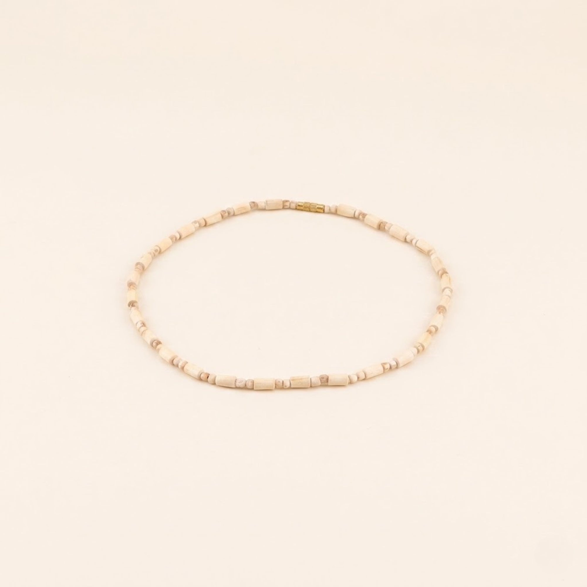 Close up flat lay of a handmade Tulsi bead necklace with cylindrical shaped wood beads