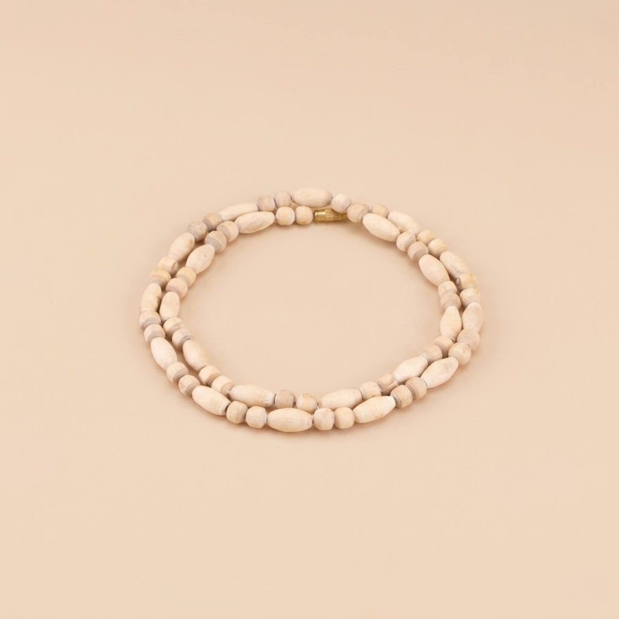 Close up flat lay of an original Tulsi bead necklace with oval shaped wood beads