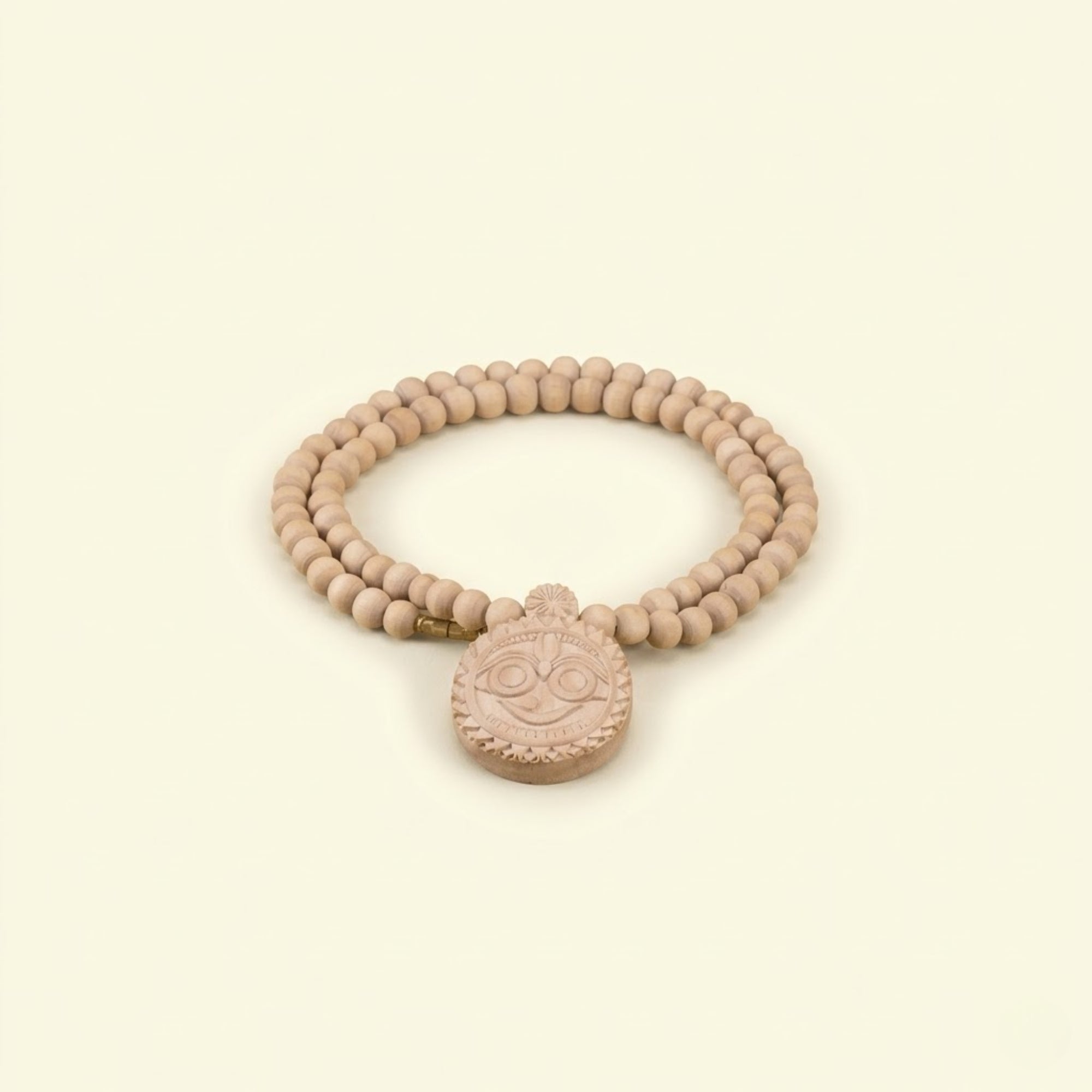 Close up of an exquisite hand-carved wooden Jagannath Ji pendant on an authentic Tulsi mala