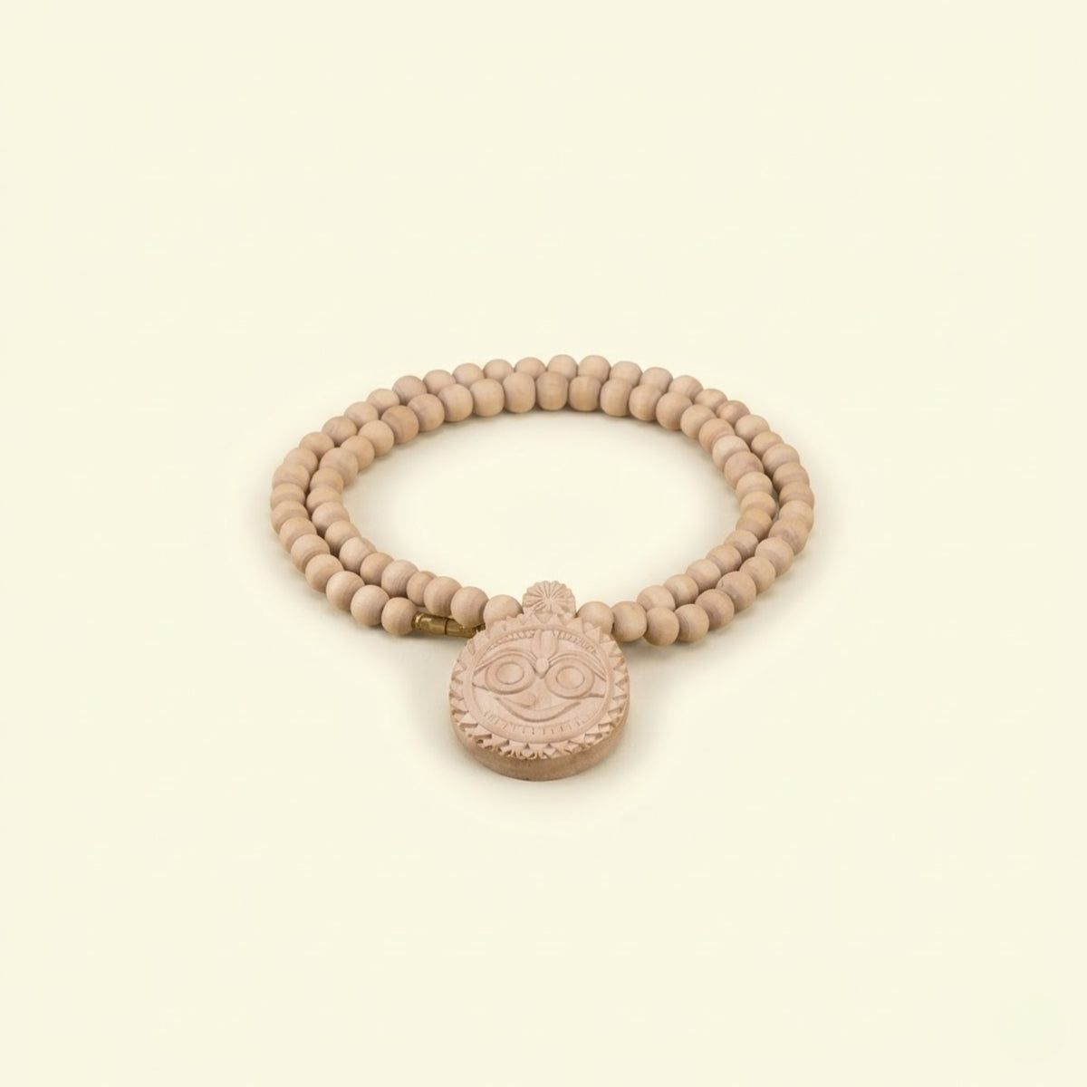 Close up of an exquisite hand-carved wooden Jagannath Ji pendant on an authentic Tulsi mala