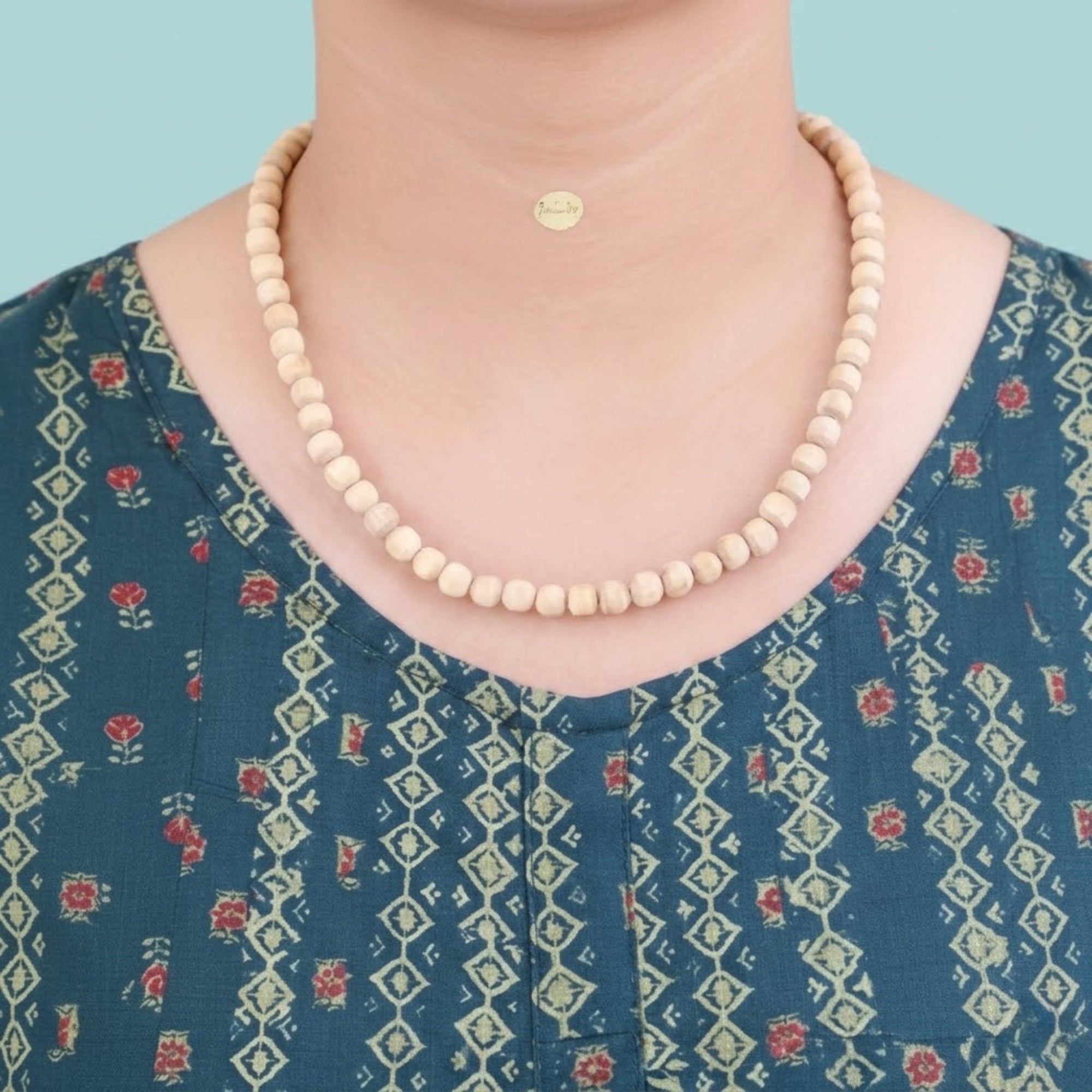 Woman wearing an original Tulsi Kanthi Mala featuring big round basil wood beads