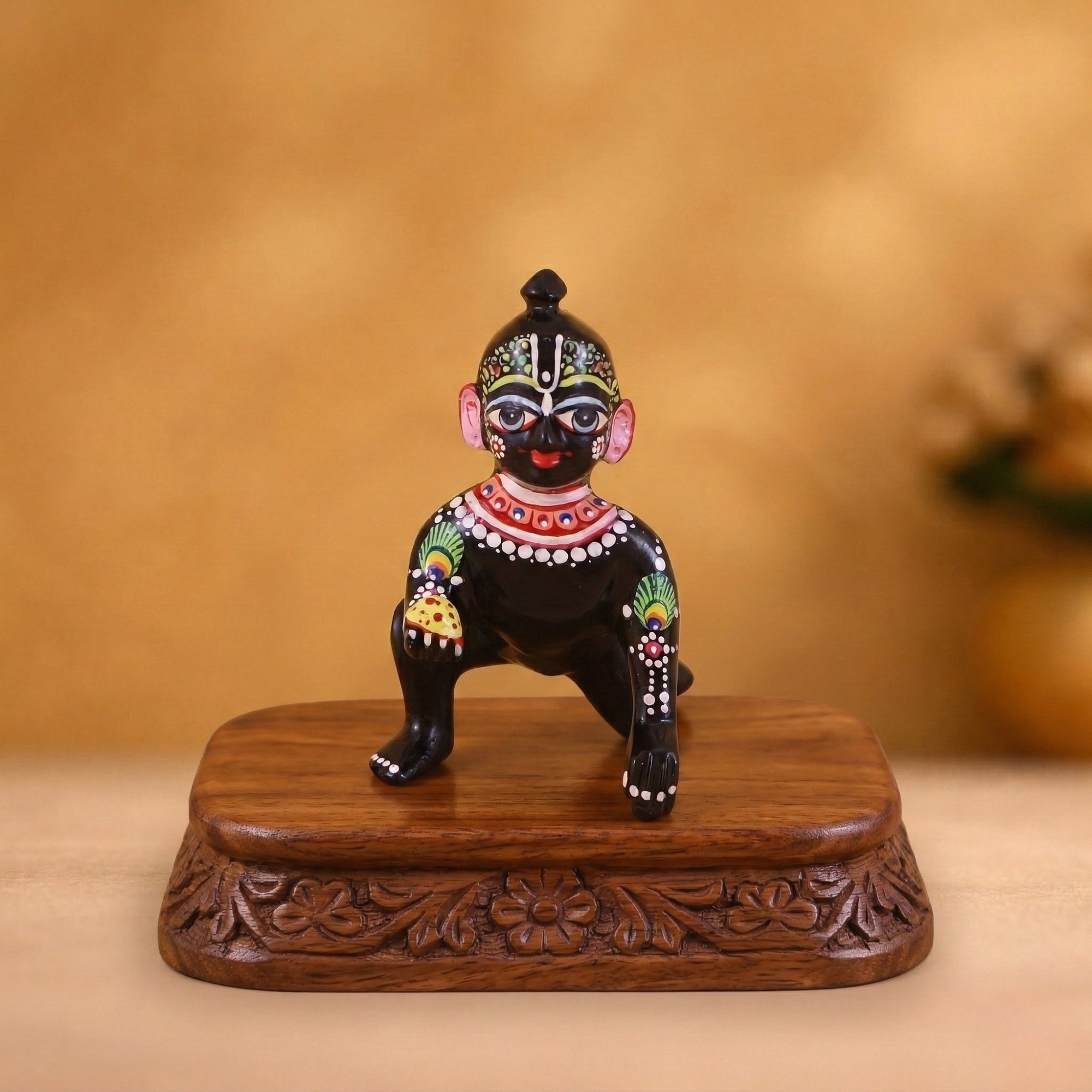 Decorative Shringar black brass Laddu Gopal idol displayed on a traditional wooden base