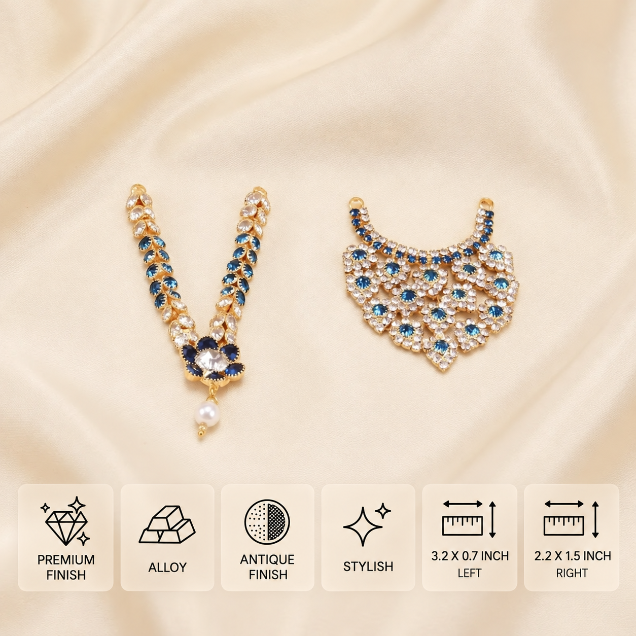 Two gold-toned imitation idol necklaces with blue and clear stones, one with a pearl drop, on cream satin features card
