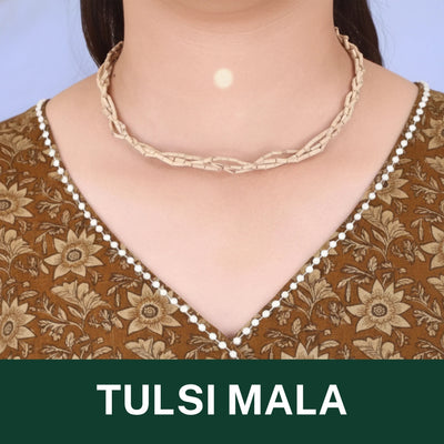 Braided beige tulsi mala necklace with a delicate white beaded edge, set against a brown floral top.