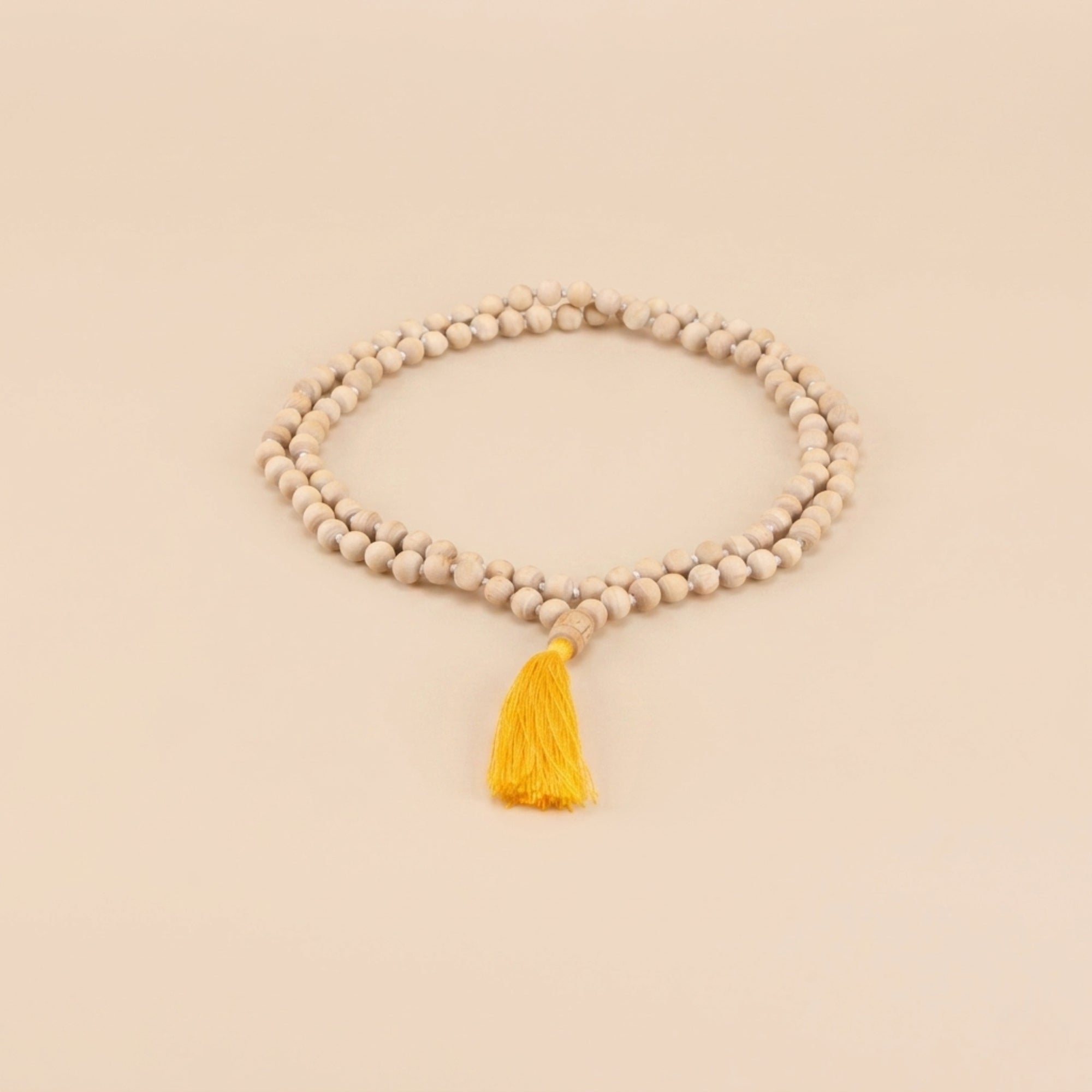 Close up of the intricately carved wooden Guru bead on a traditional Tulsi japa mala