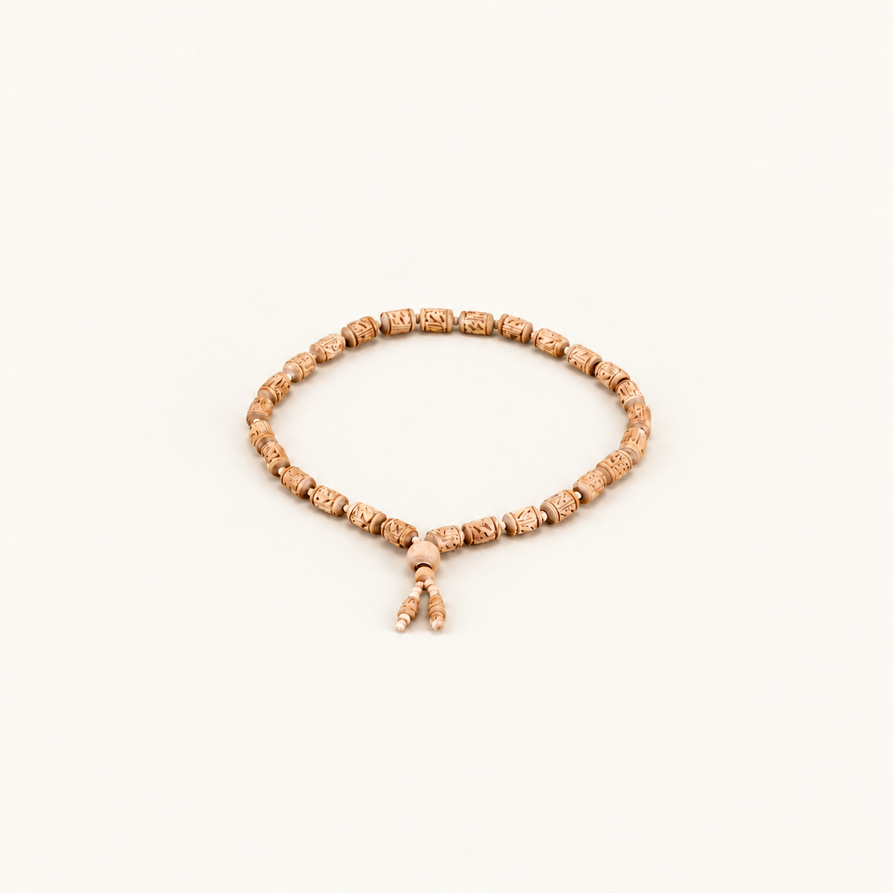 Carved Tulsi bead mala arranged in a circle with two dangling bead ends on an off-white background.