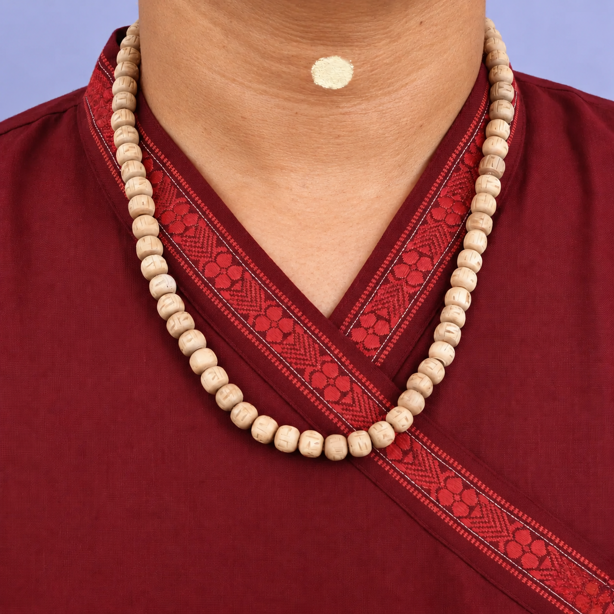 Tulsi kanthi mala with carved wooden beads worn with a maroon kurta.