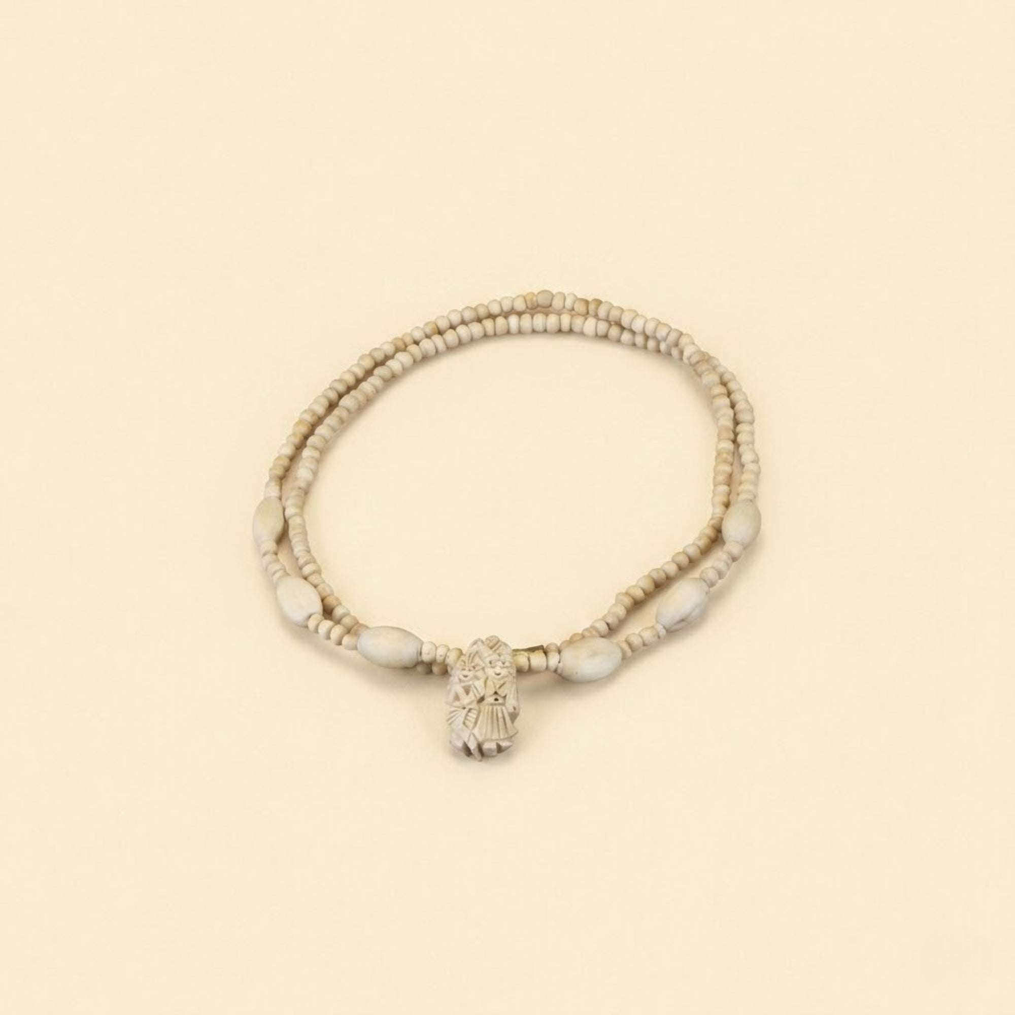 Close up flat lay of an original Vrindavan Tulsi bead necklace featuring a Radha Krishna pendant