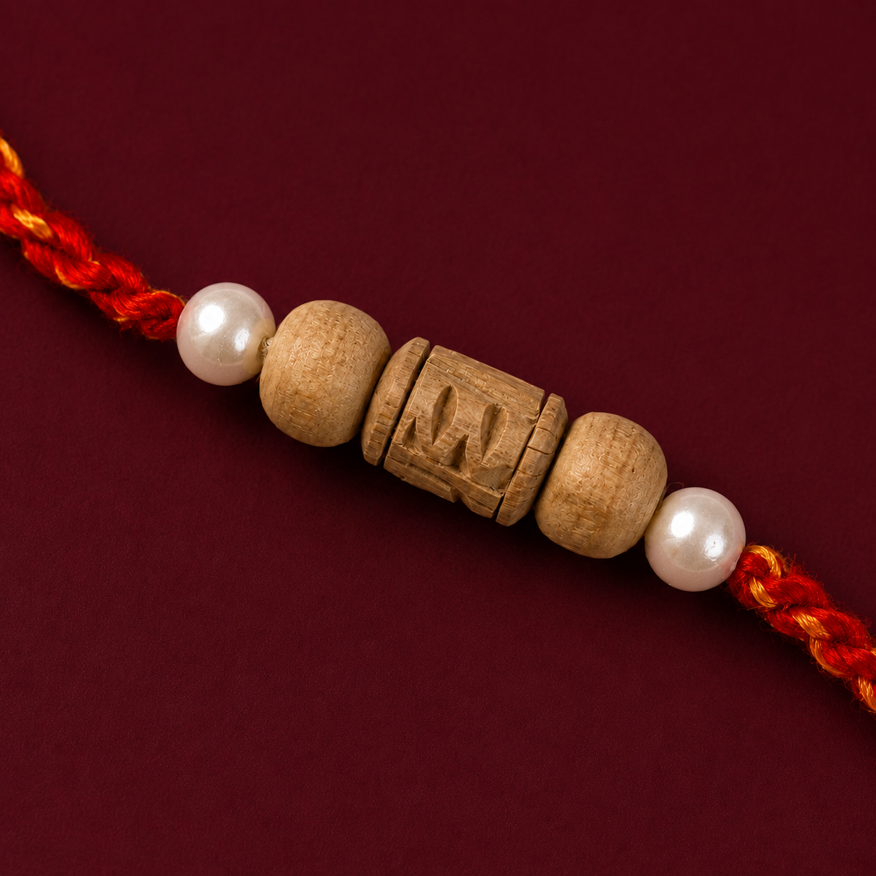 Close up of hand-carved Tulsi wood and pearl beads on a handmade rakhi
