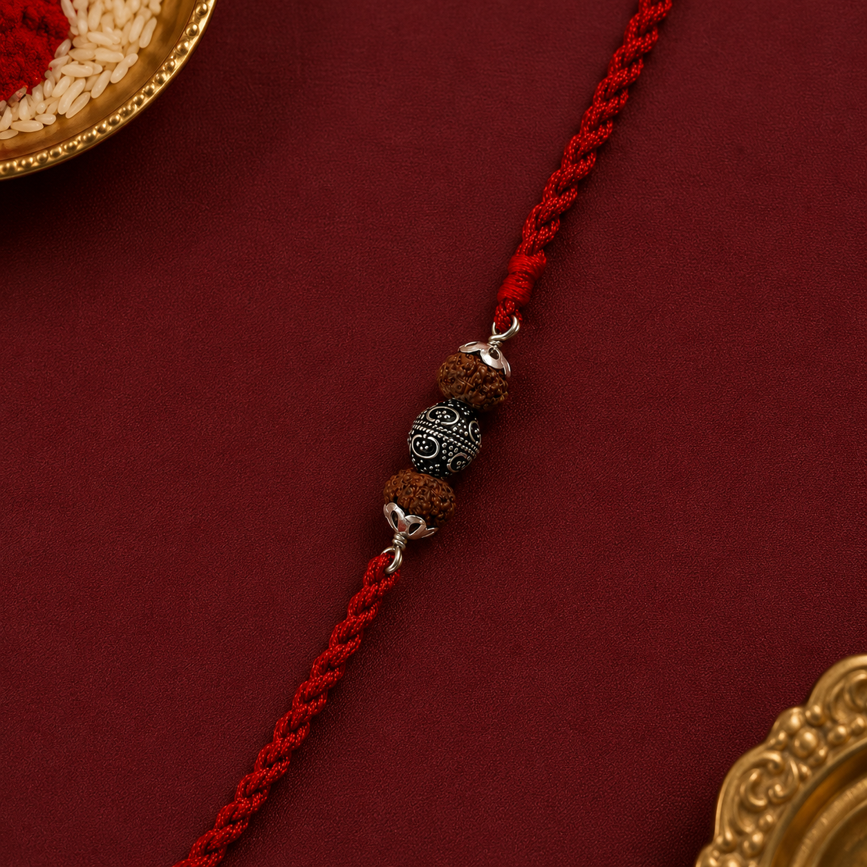 Close up view of 925 sterling silver capped carved floral Rudraksha bead with silver accent spacers on red thread