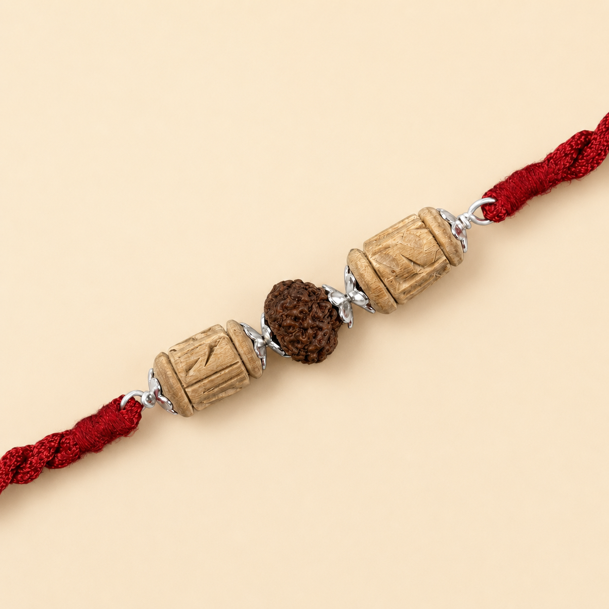 Close up view of 925 sterling silver capped central Rudraksha bead and carved Tulsi cylinders on red cord