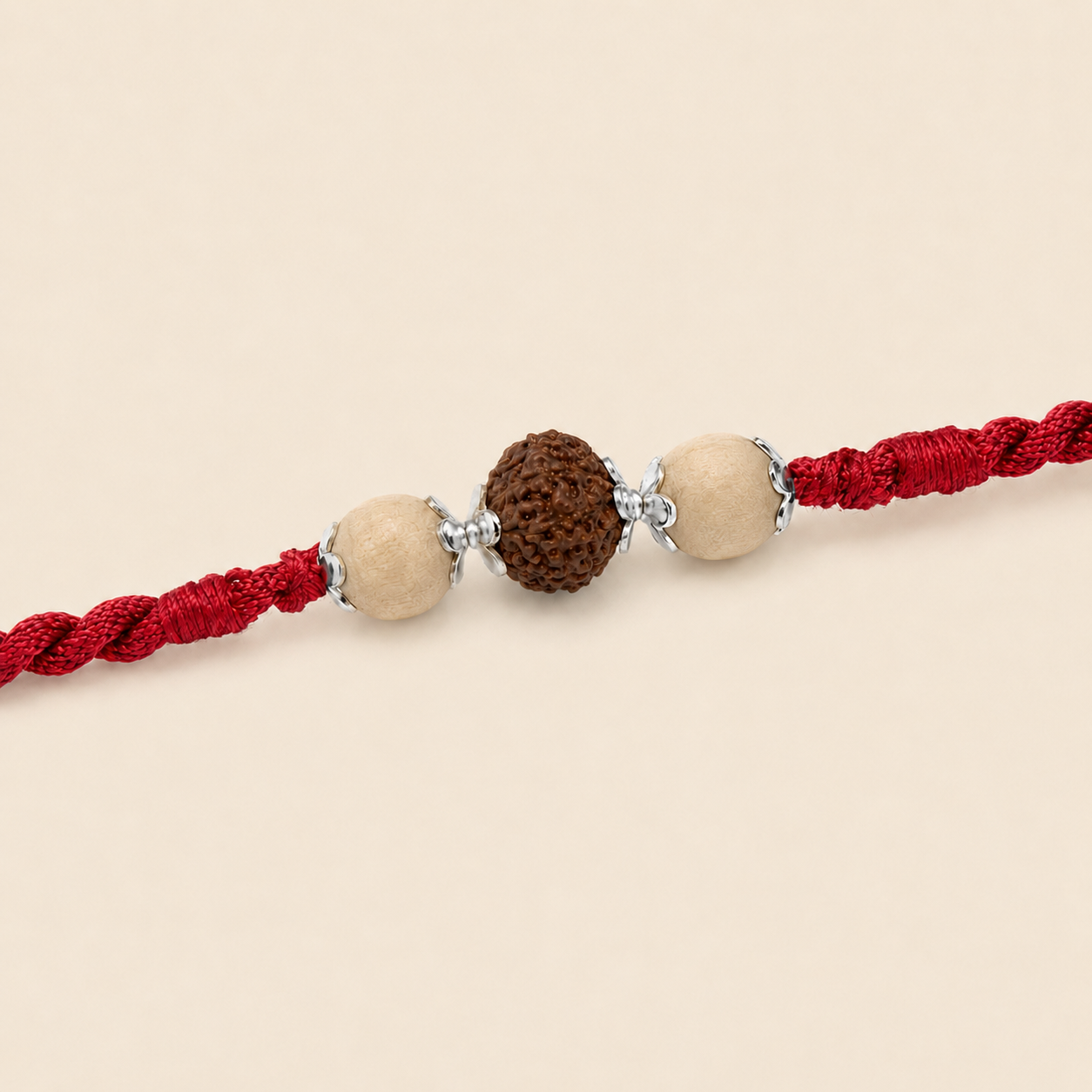 Close up view of 925 sterling silver capped central Rudraksha bead and round Tulsi beads on red cord