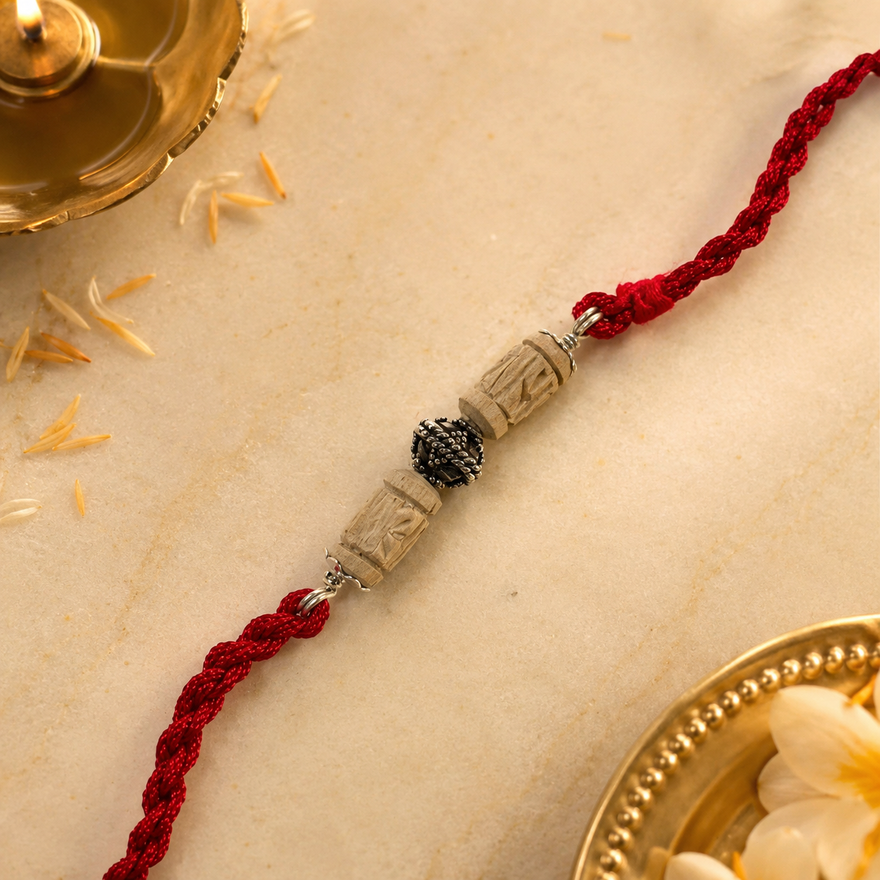 Angled close up view of 925 sterling silver capped sacred Tulsi beads on cream silk cloth