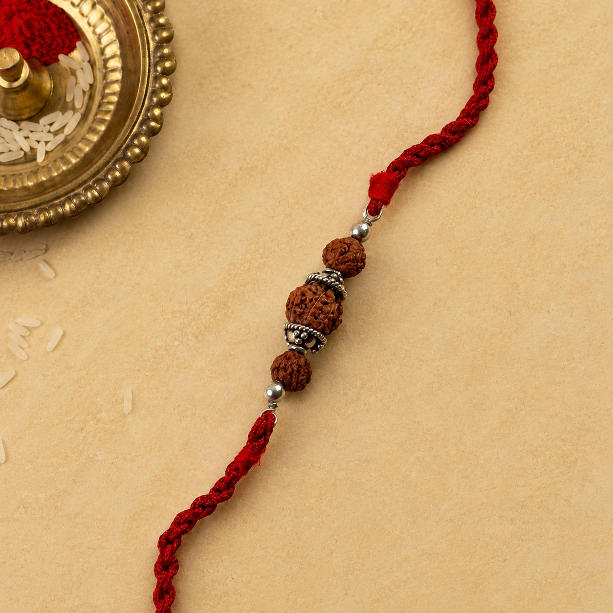 Close up view of 925 sterling silver filigree capped Rudraksha beads on red thread with pooja thali