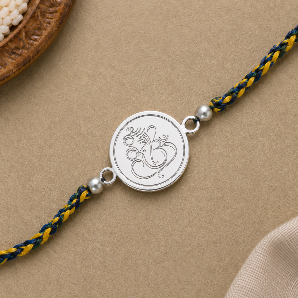 Close up view of engraved 925 sterling silver coin charm detailing Lord Ganesha calligraphy figure
