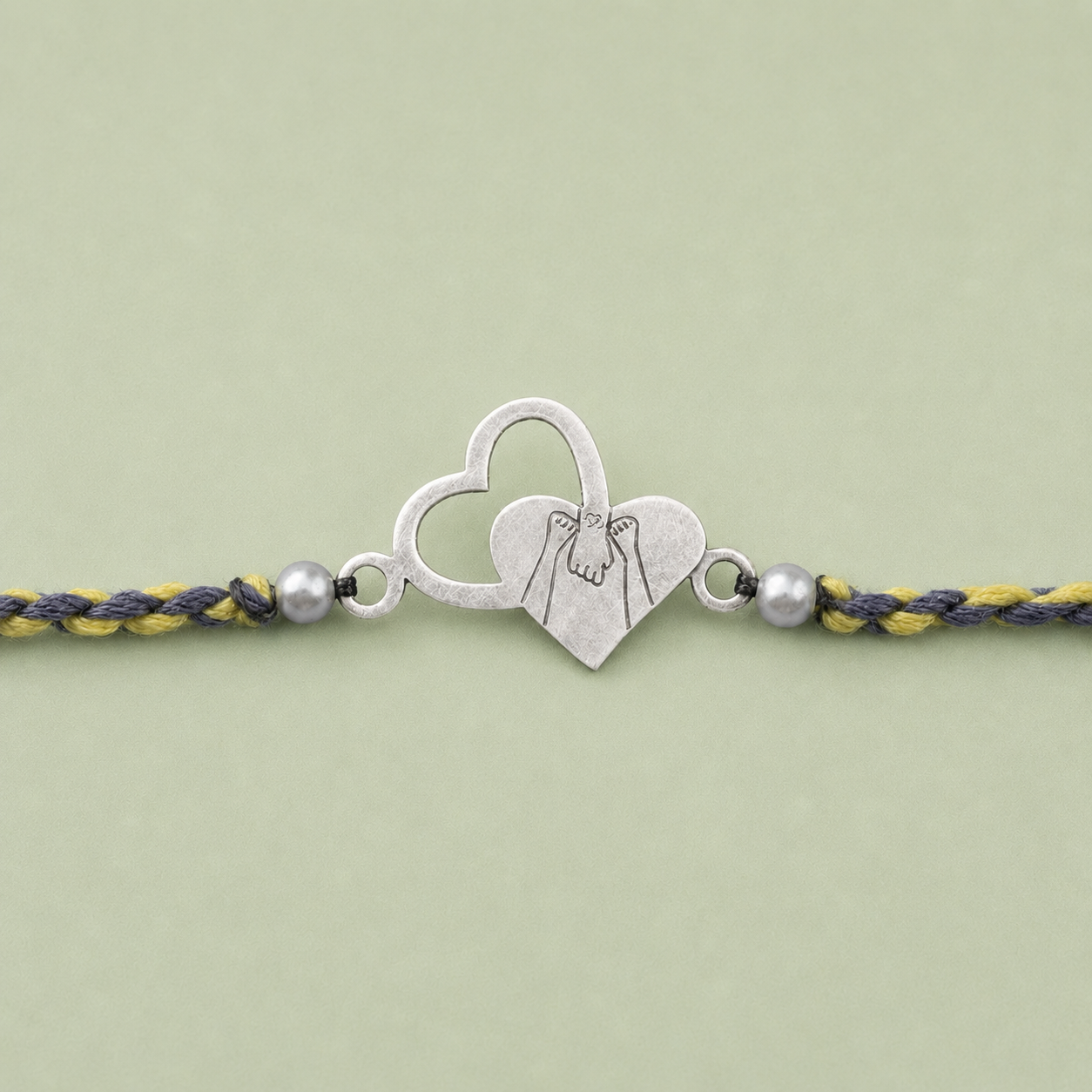 Close up view of 925 sterling silver dual interlocking heart charm with pearl accents