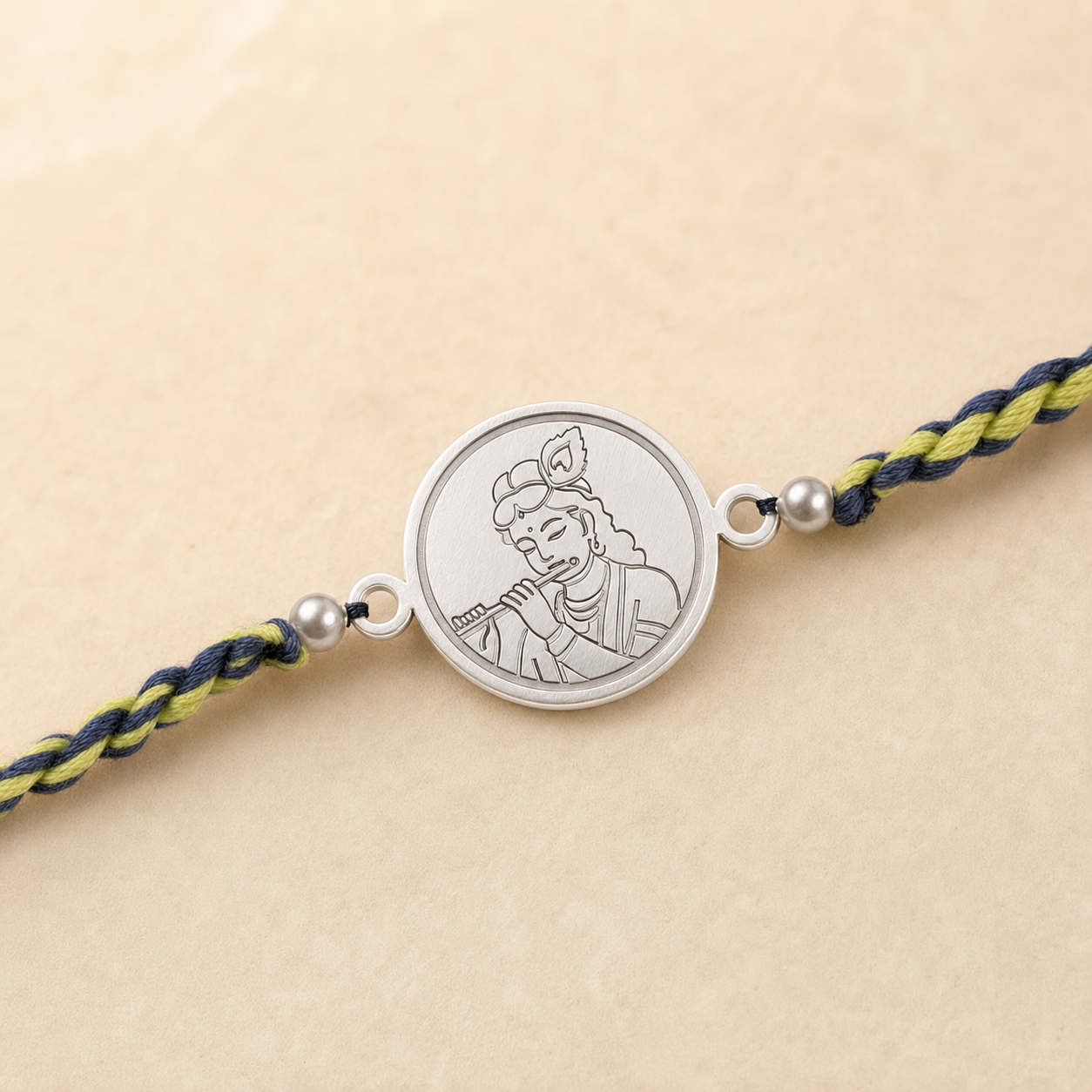 Close up view of engraved 925 sterling silver coin charm detailing Lord Krishna face and Mukut