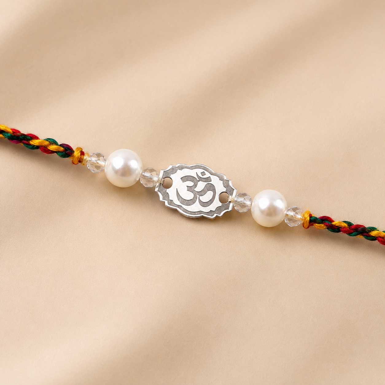 Close up view of engraved 925 sterling silver Om oval charm with pearl beads on thread
