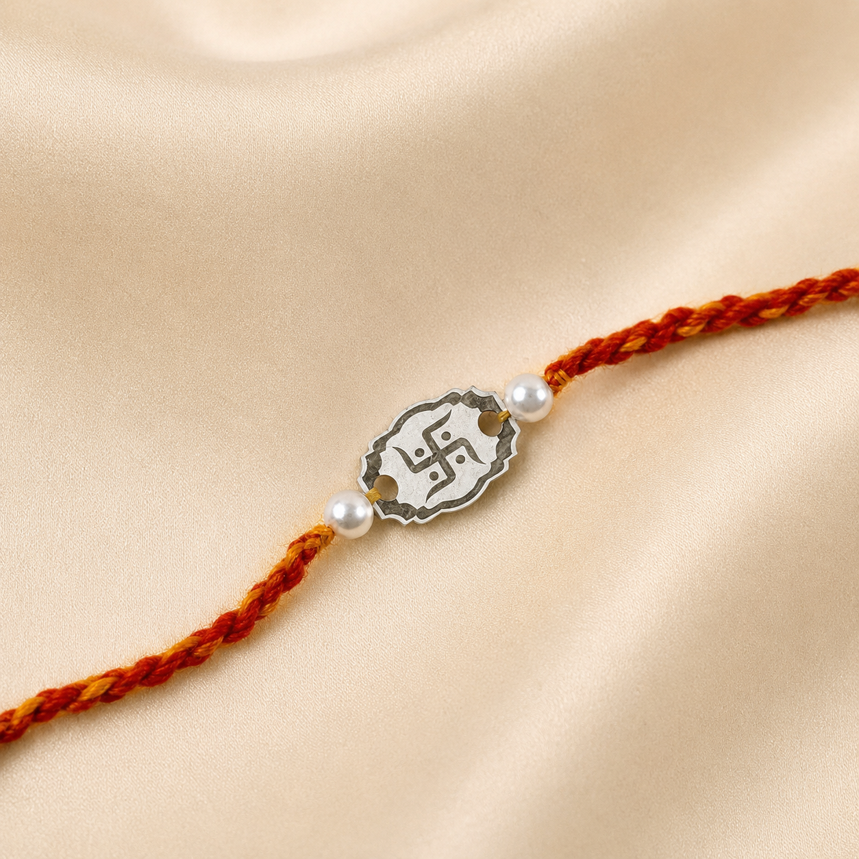 Close up view of openwork 925 sterling silver oval Swastik charm with pearl beads on red thread