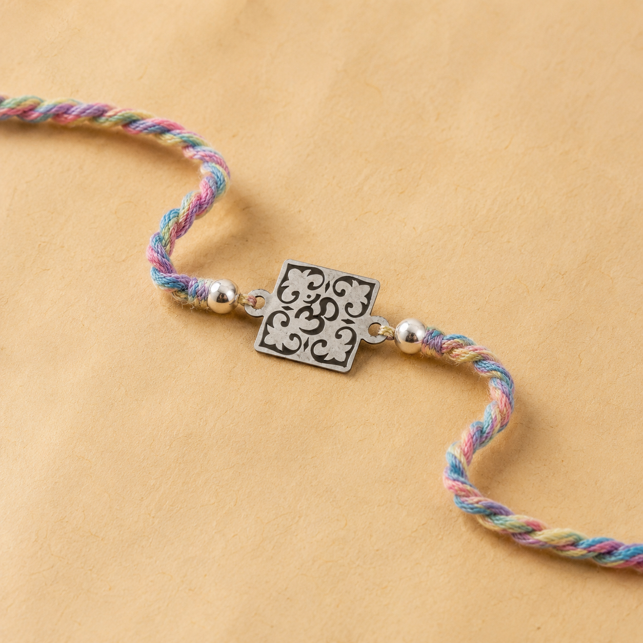 Close up view of 925 sterling silver square filigree floral openwork charm with pearl beads on multi color thread