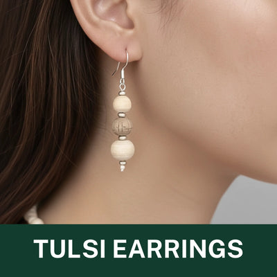 Dangling earring made of three cream-colored tulsi wood beads with silver findings.