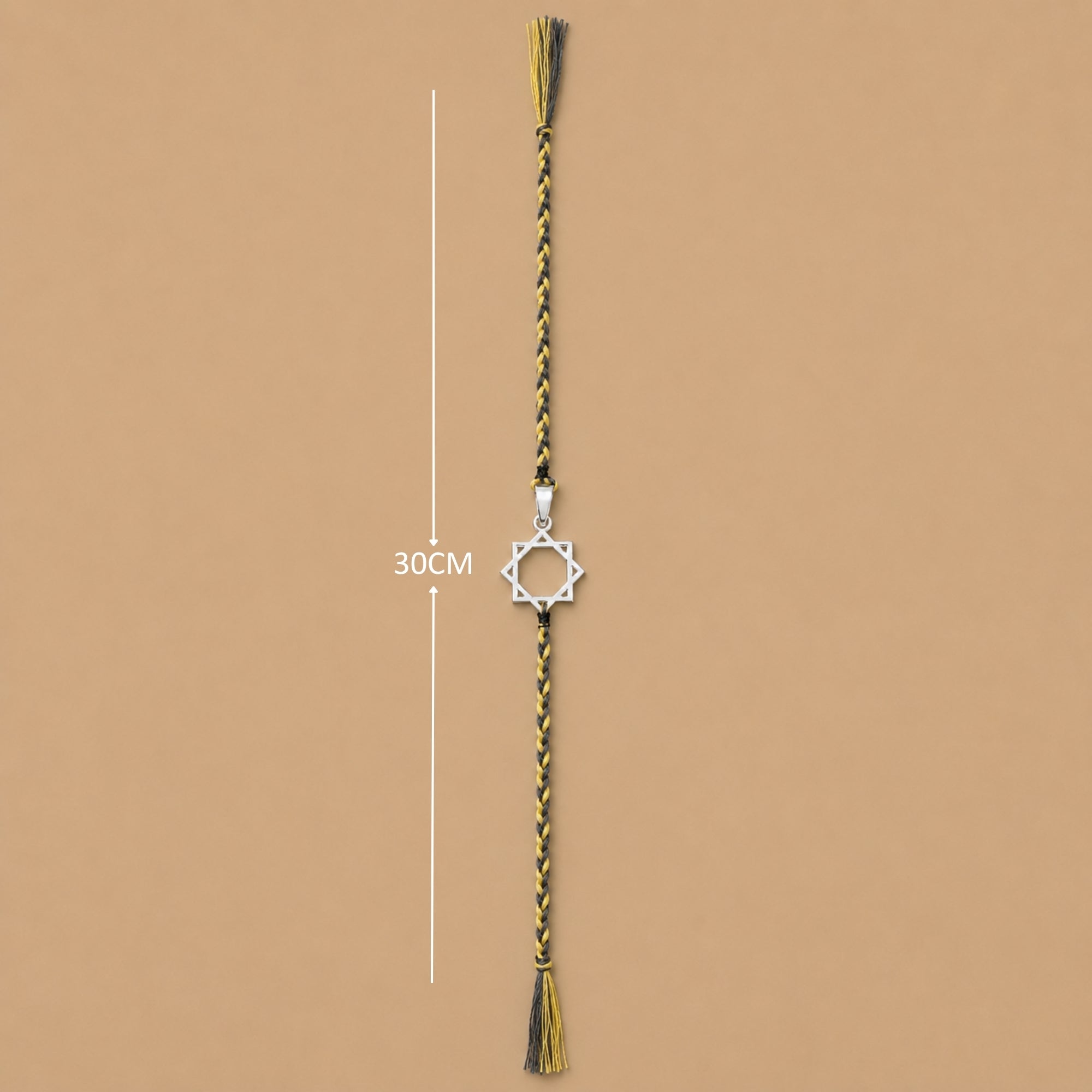 Full length view of designer silver star rakhi showing thread layout and tassel ends