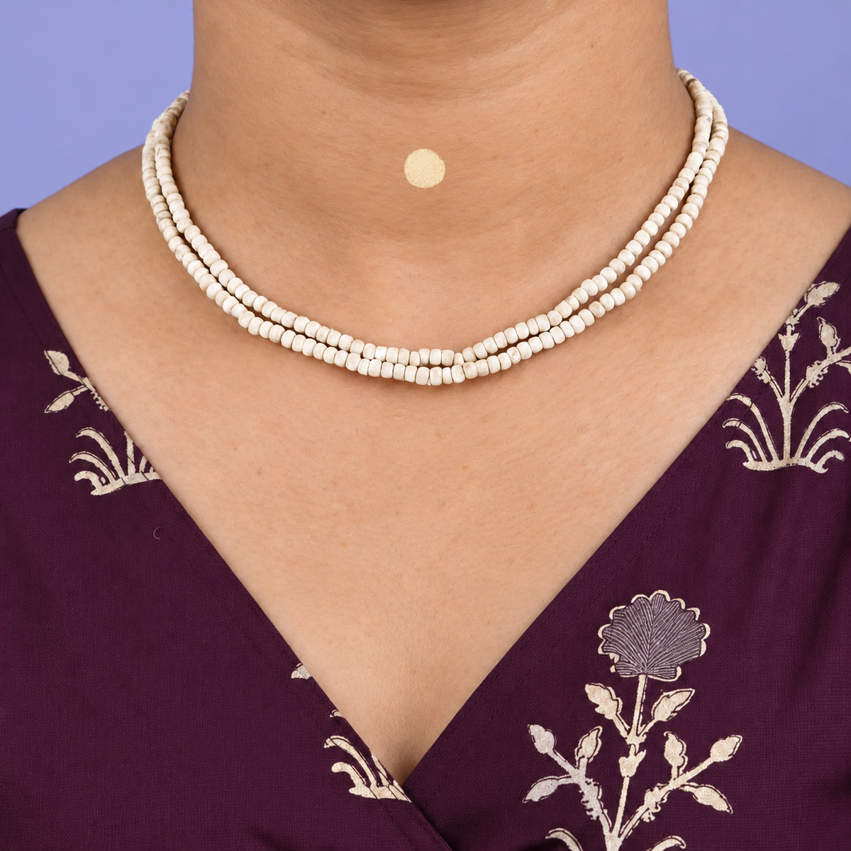 Double-strand Tulsi kanthi mala with small rounded wooden beads worn with a purple floral kurta.
